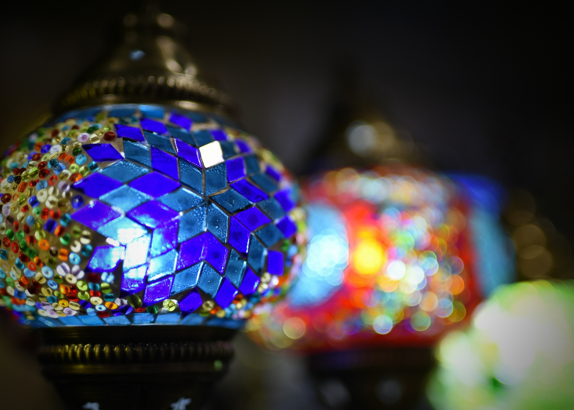 Close up of a lamp made of blue and multicolored glass pieces. 