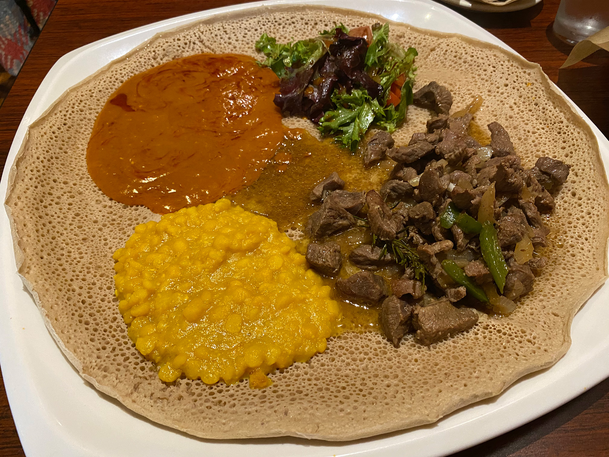 Spread of Ethiopian stews on top of a round of injera.
