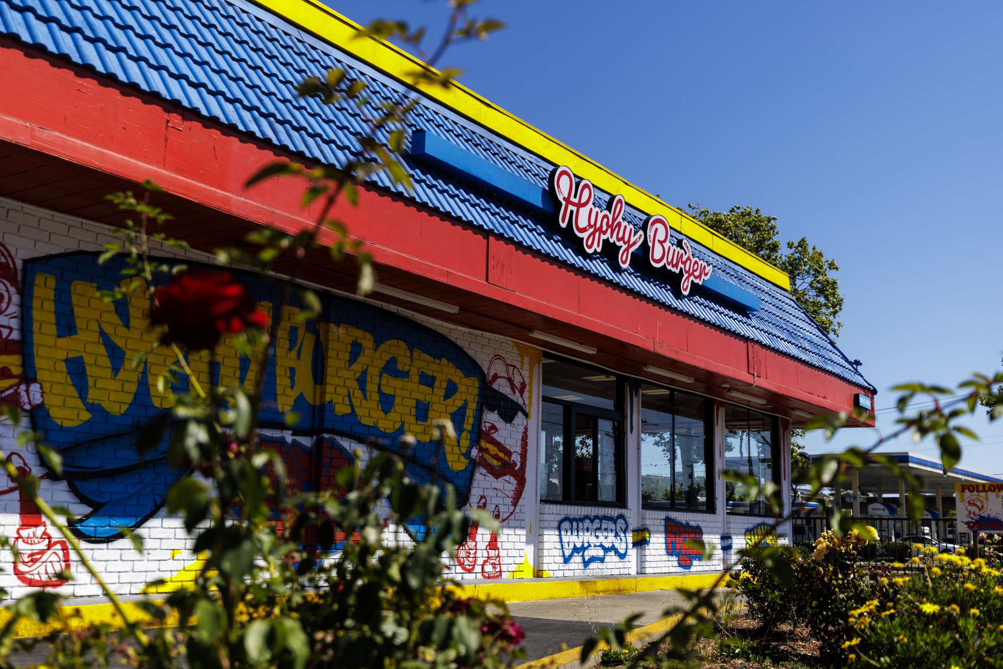 Colorful red, blue and yellow exterior of a burger shop. The sign reads "Hyphy Burger."