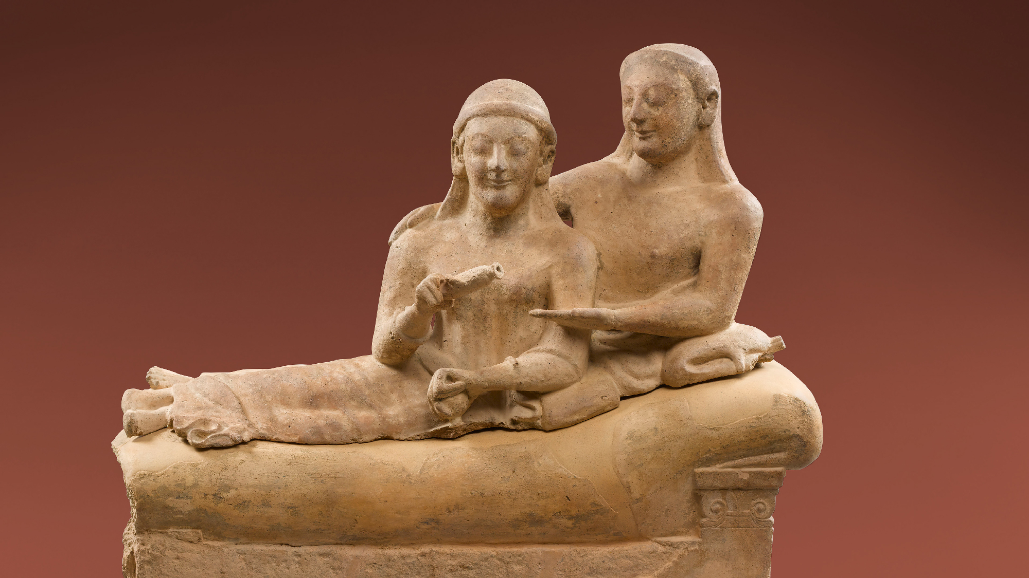 terracotta sculpture of man and woman lounging together