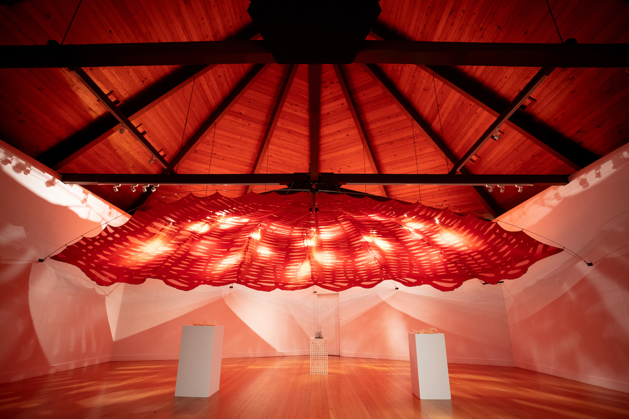 exposed beams with hanging red fabric sculpture underneath