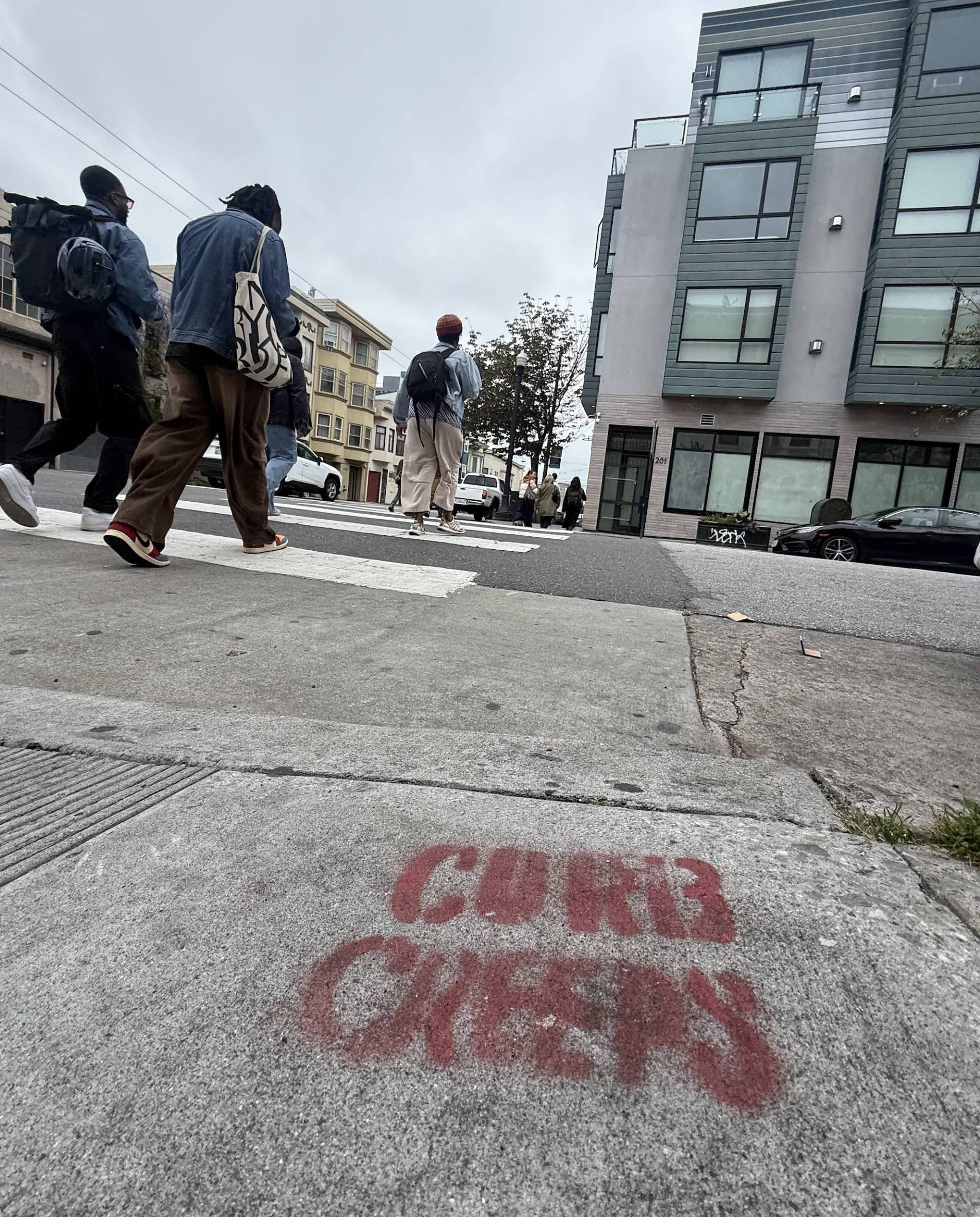 The words "CURB CREEPS" etched in aerosol spray on the corner of 17th and Capp Street in San Francisco.