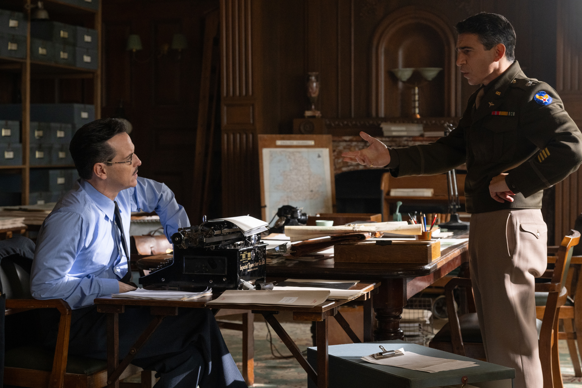 two men face each other over typewriter