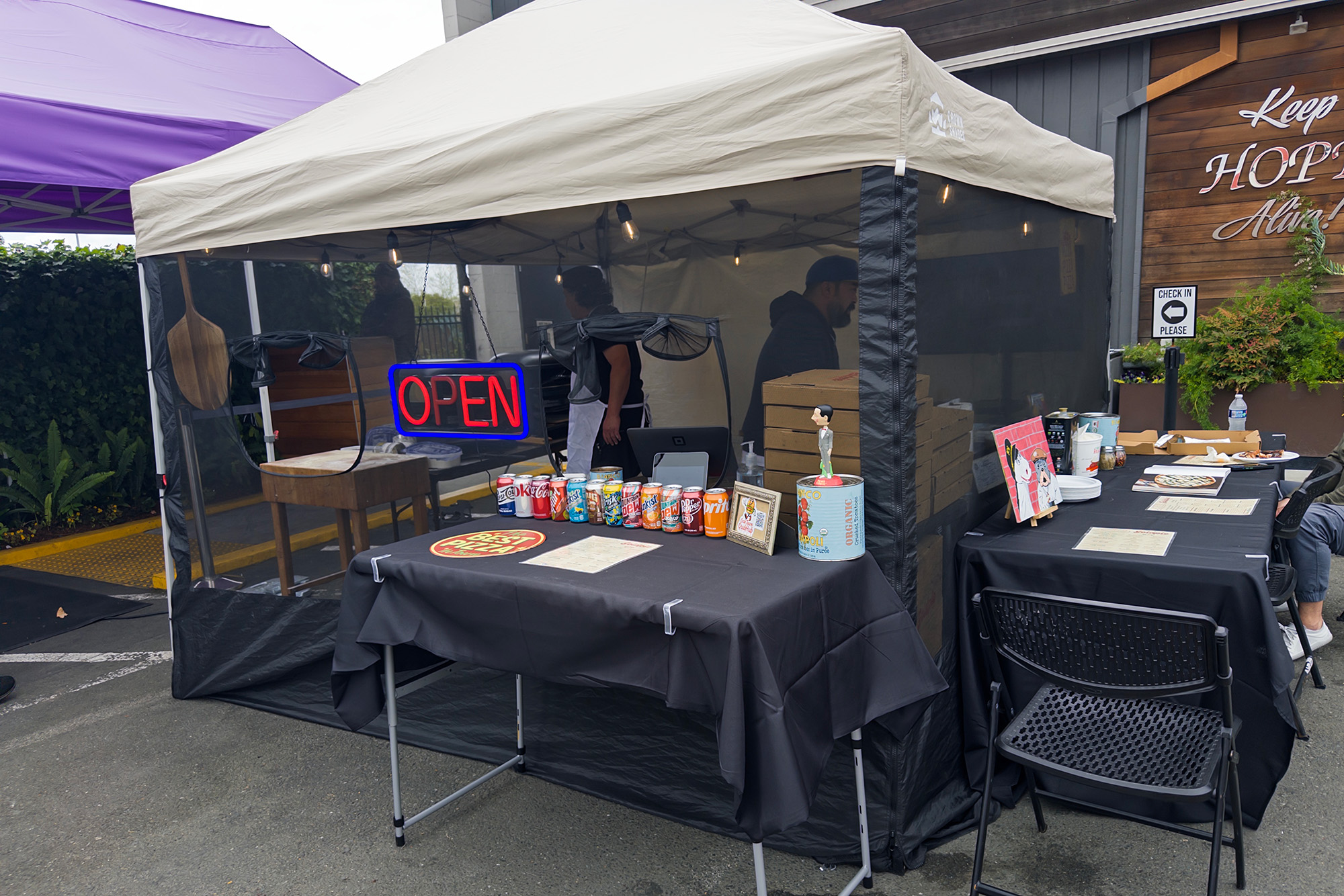 A food tent set up in front of a marijuana dispensary.