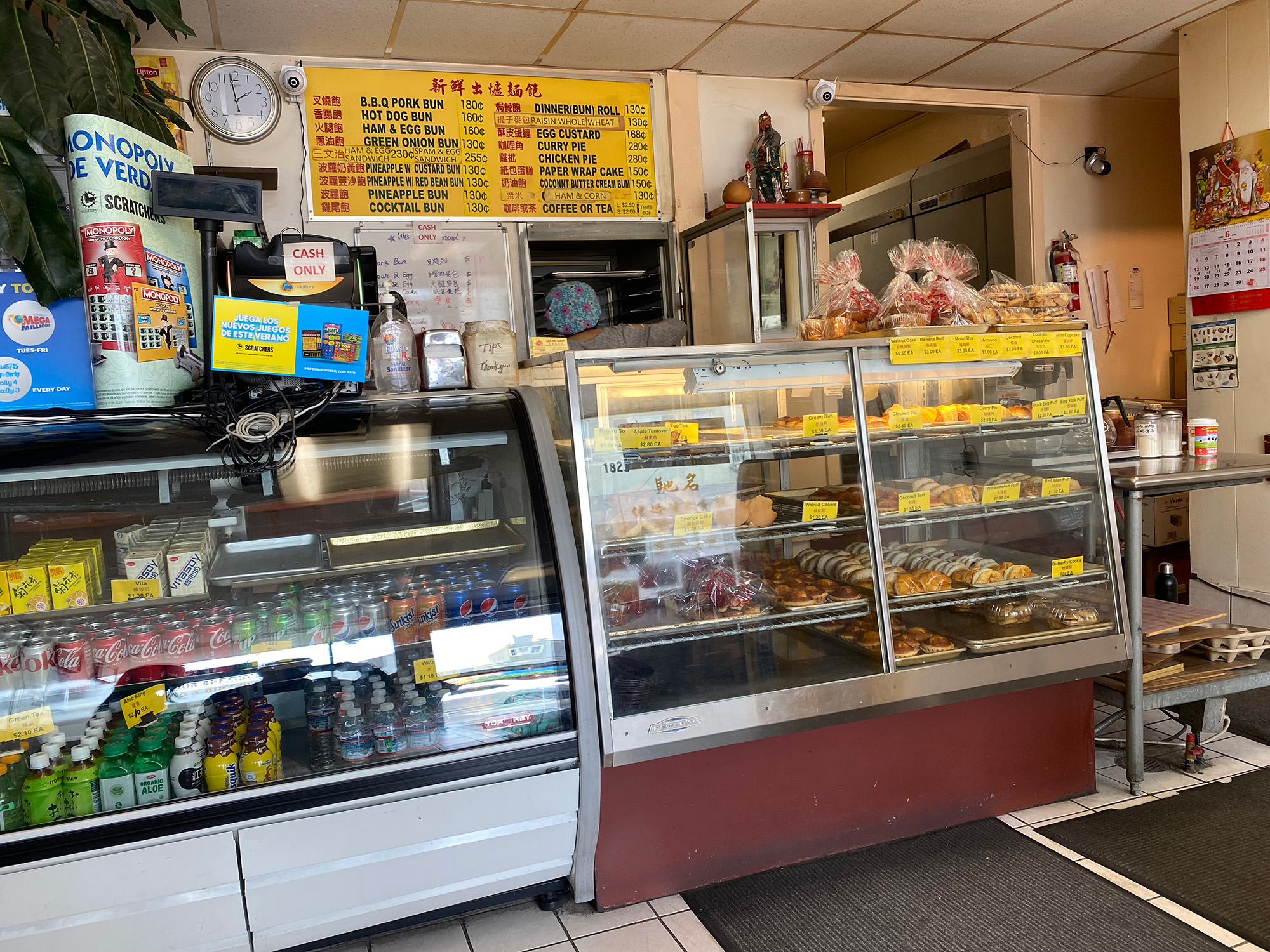 The interior of a Chinese bakery, with a fully stocked display case and old-fashioned signage visible.