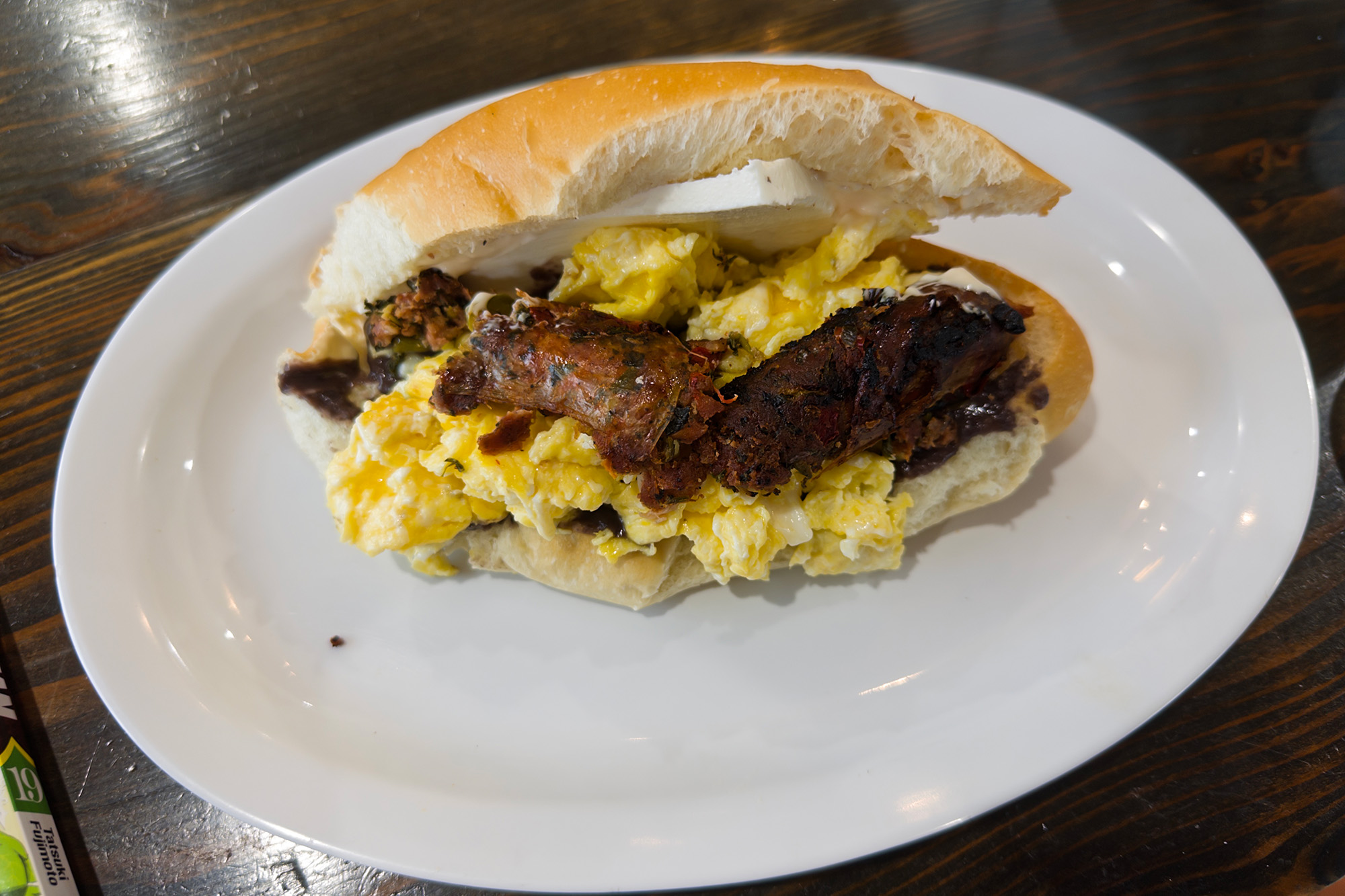 Breakfast sandwich with sausage, scrambled egg and queso fresco.