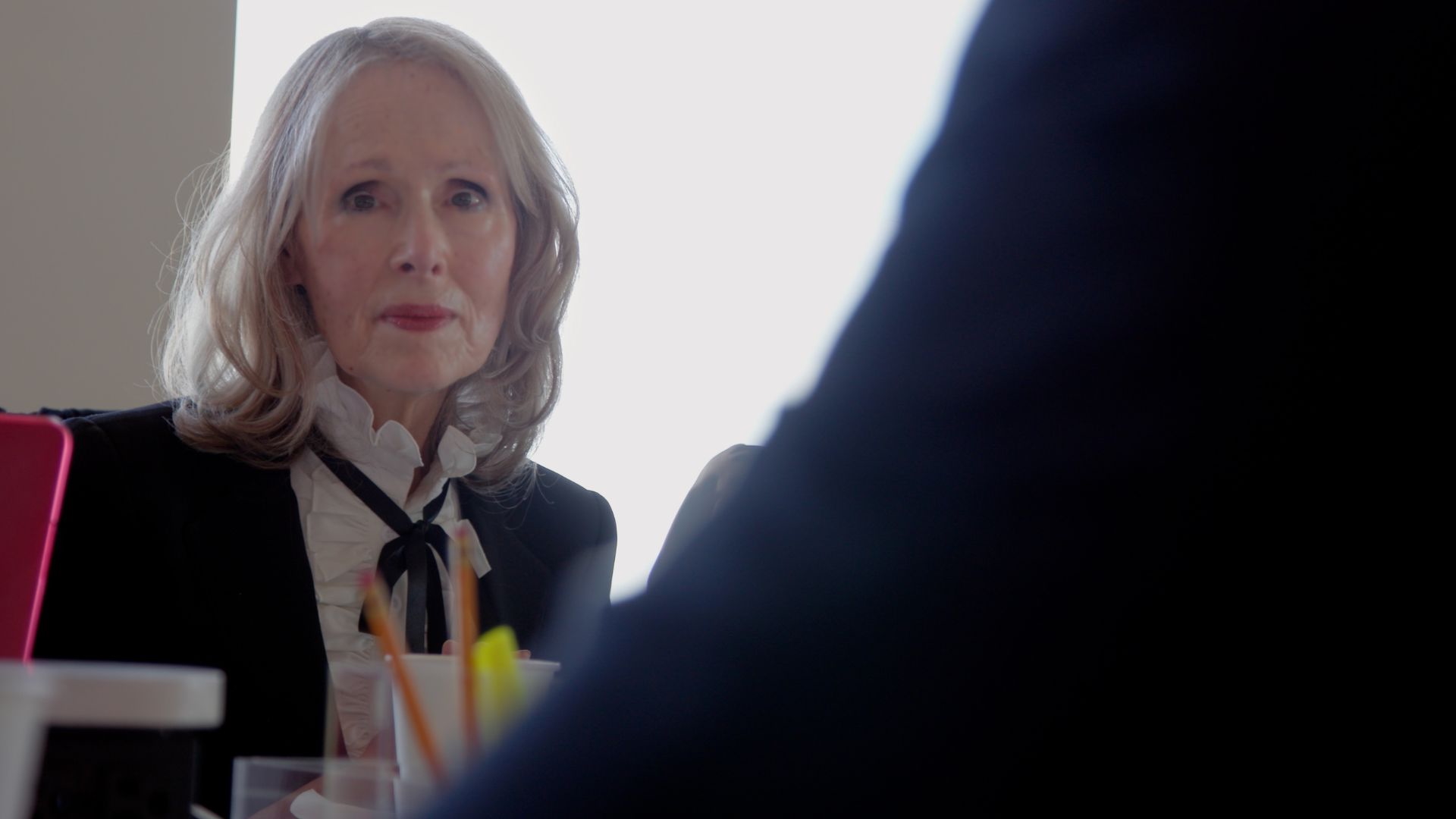 older white woman in suit jacket and string tie