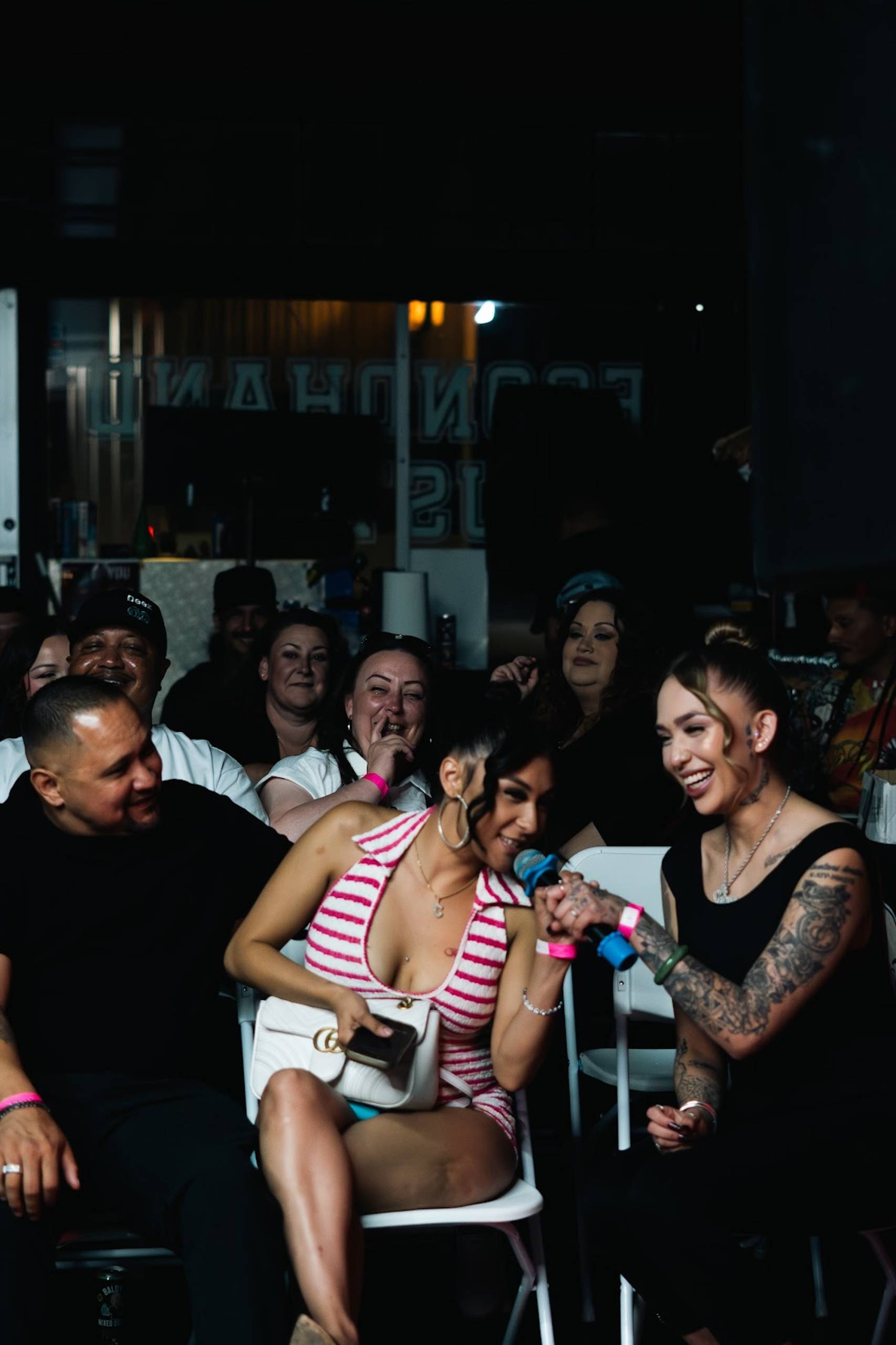 People in a crowd, seated at an event. Laughing and smiling.