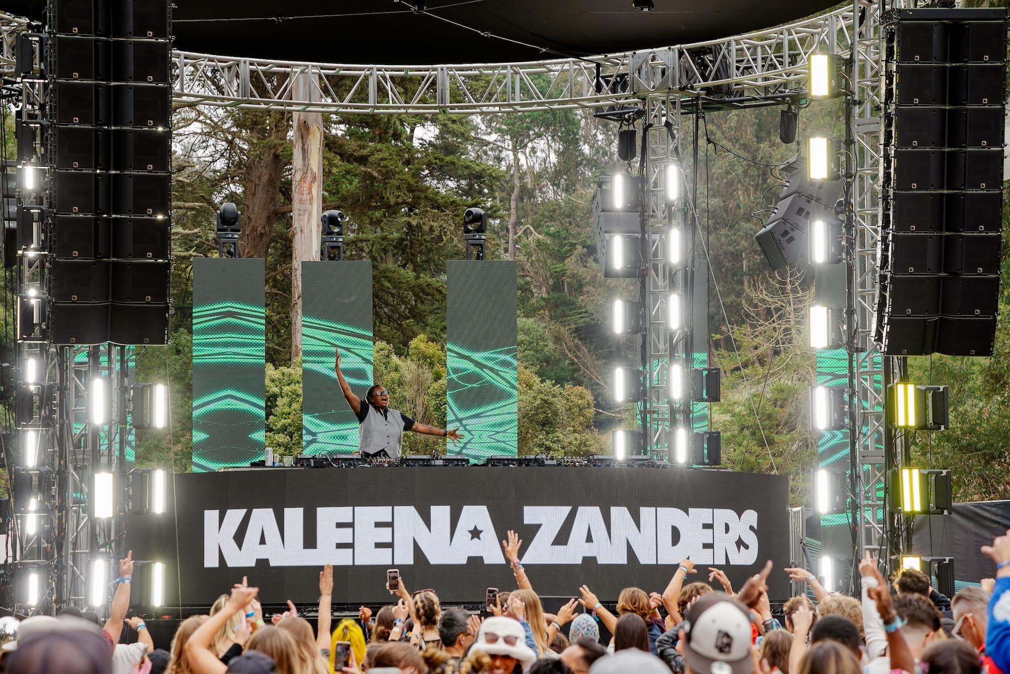 The crowd's view of a person standing behind the DJ tables.