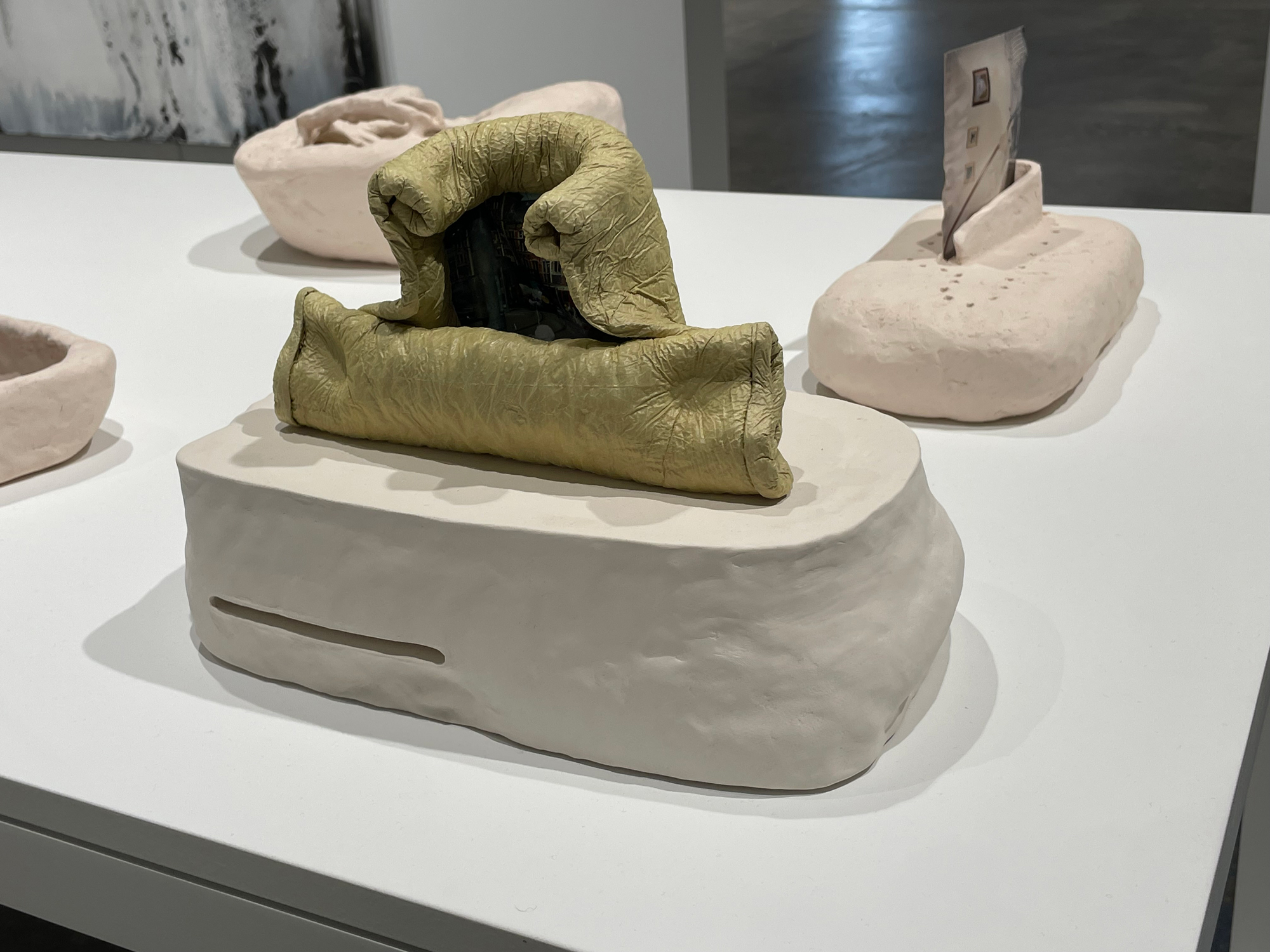 sculptures embedded with photographs sitting on pedestal