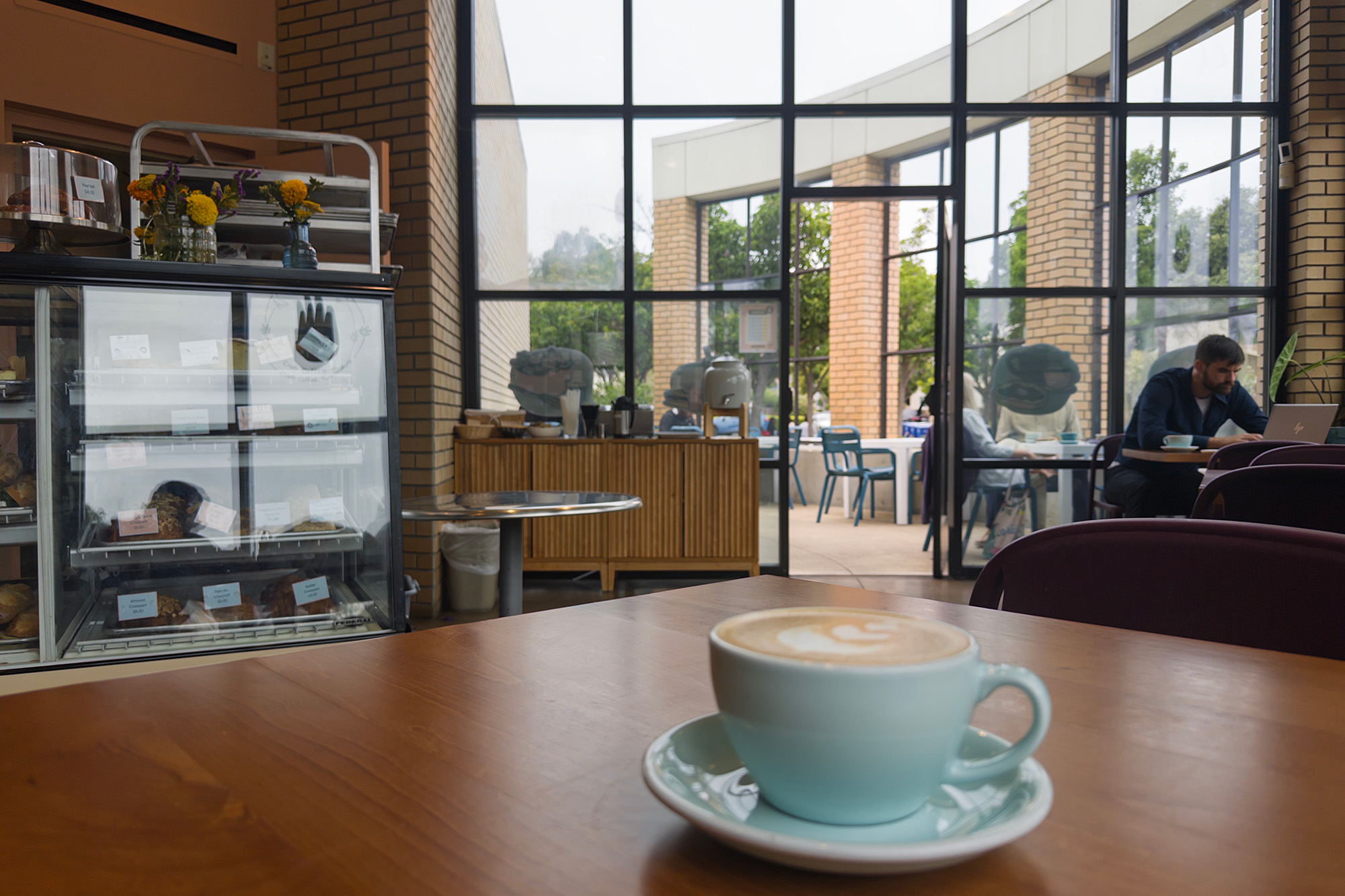 A flat white coffee drink inside an airy, sunny cafe.
