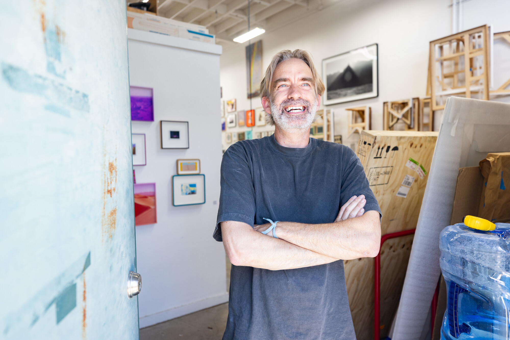 white man with gray hair smiles with arms crossed