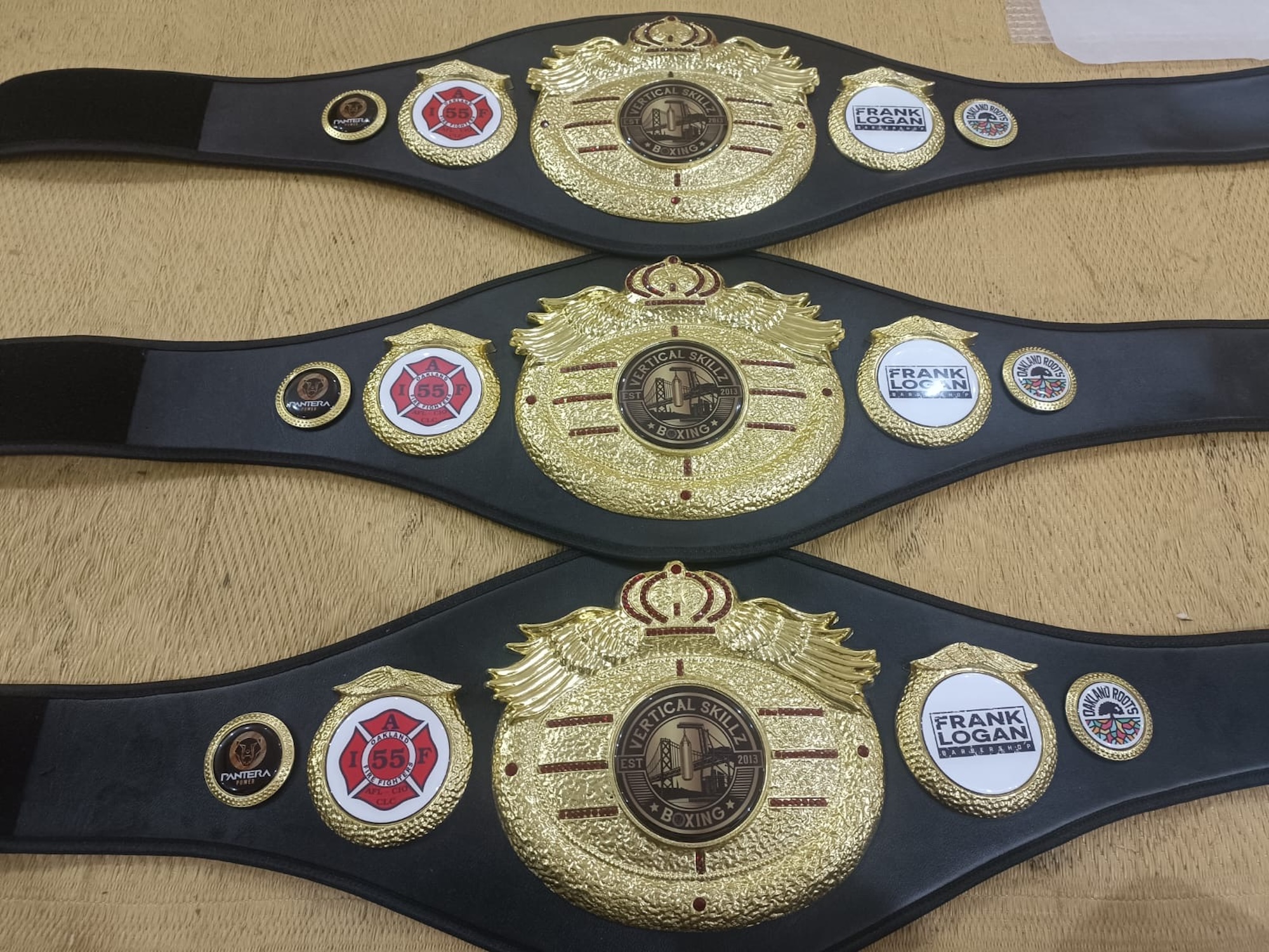 A photo of three boxing championship belts.