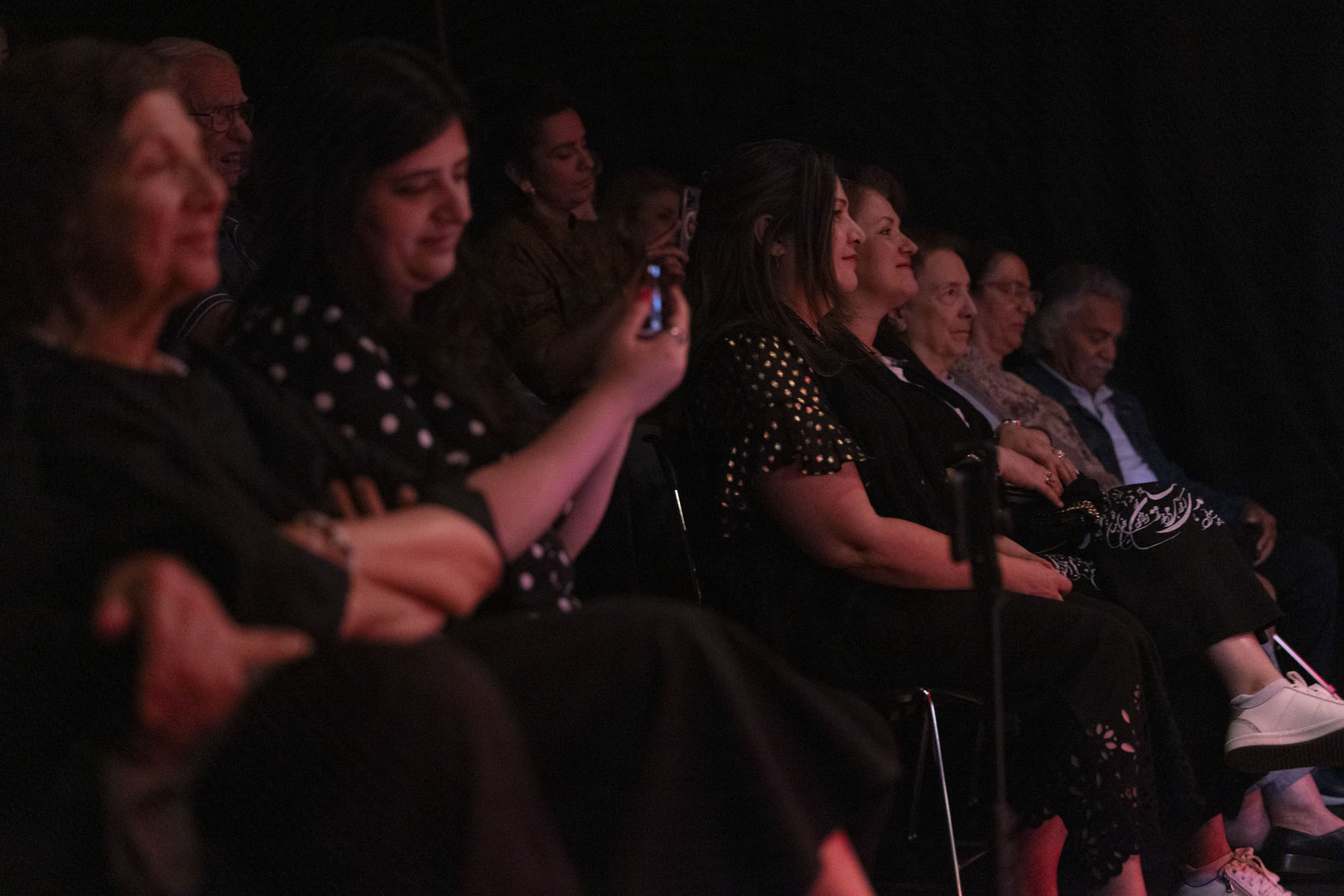 Audience members clap and sing along to a musical performance.