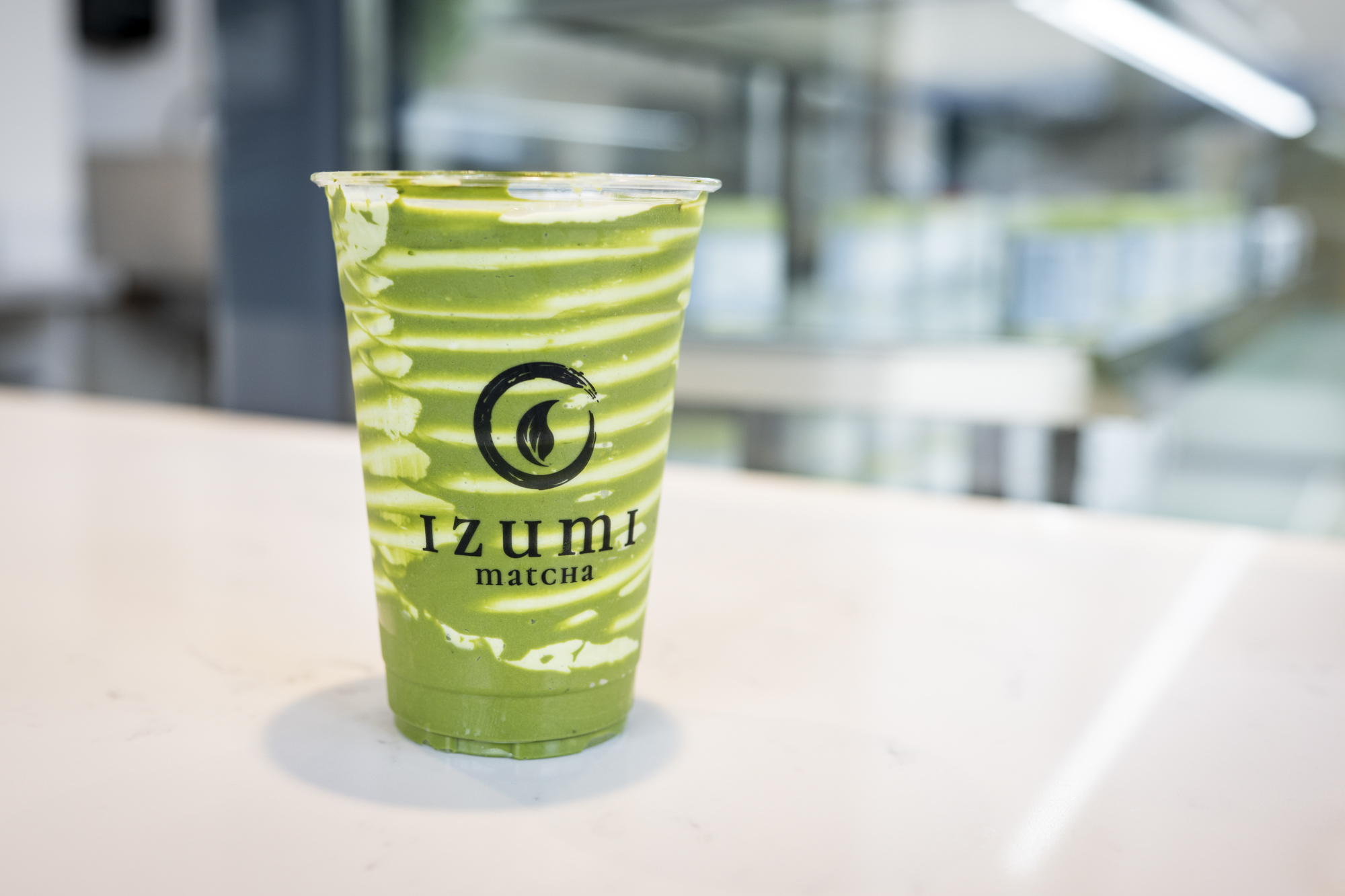 A matcha drink with white swirls of crème brûlée–flavored cream.
