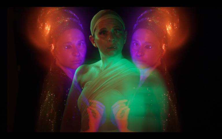 green glowing woman looks astonished, two red glowing women missing one eye flank her