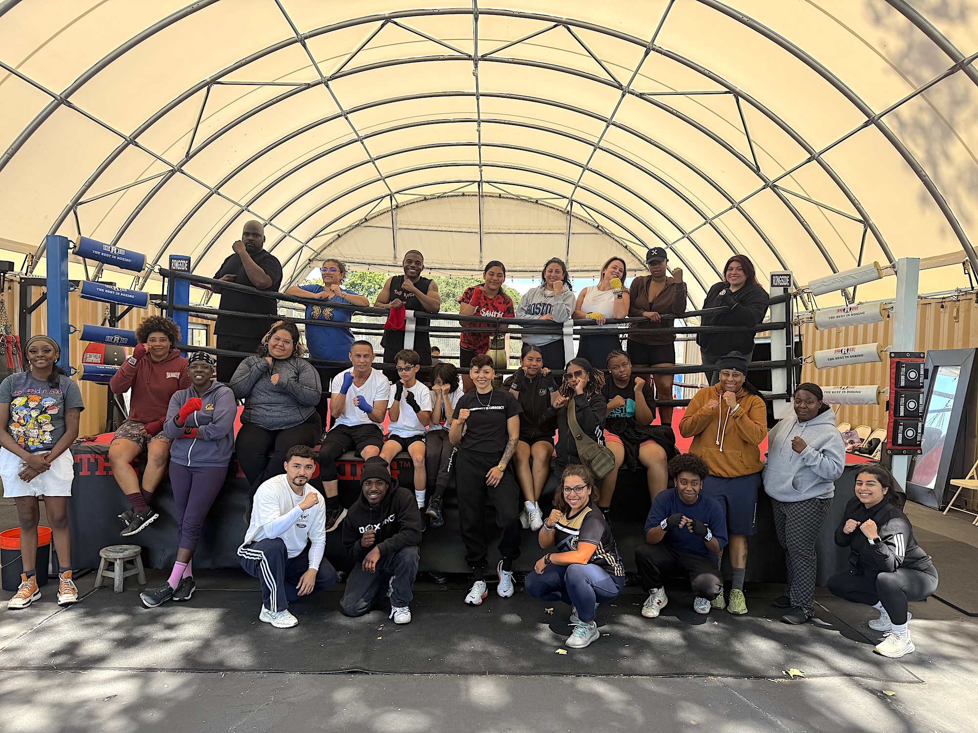 A large group of boxers pose for a photo at a boxing ring in East Oakland.