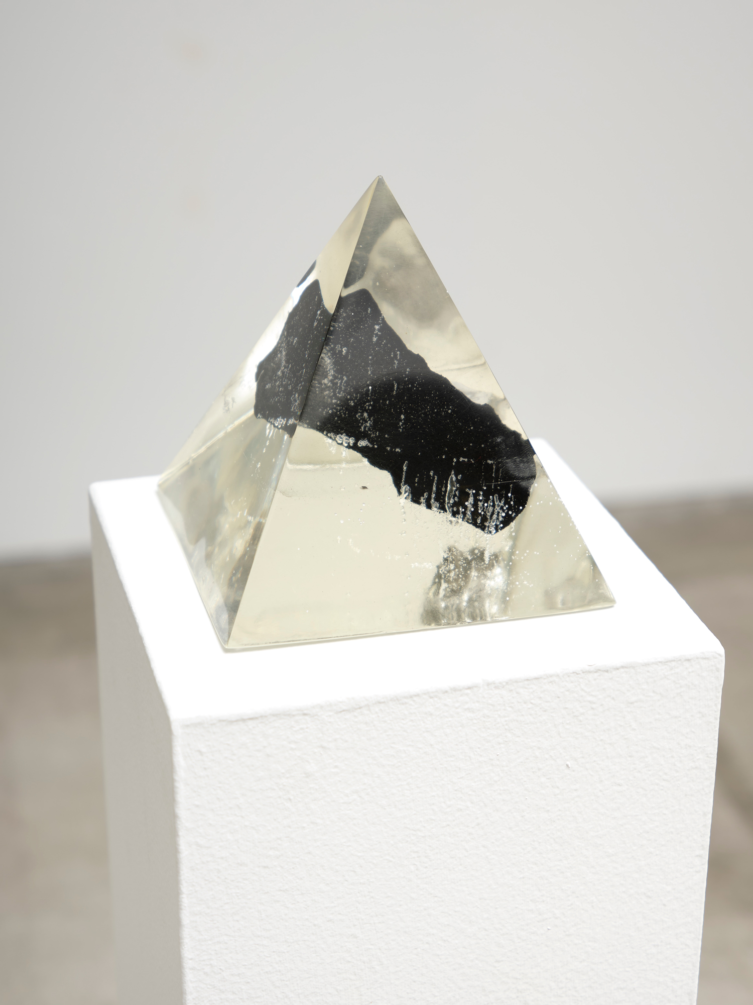 clear pyramid with embedded black fragment of SpaceX debris