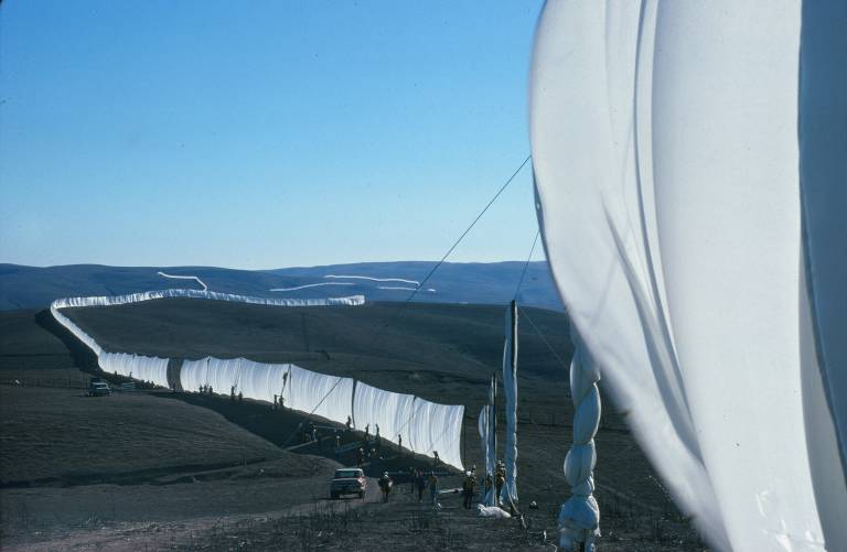 long white fabric hung as fence across hills