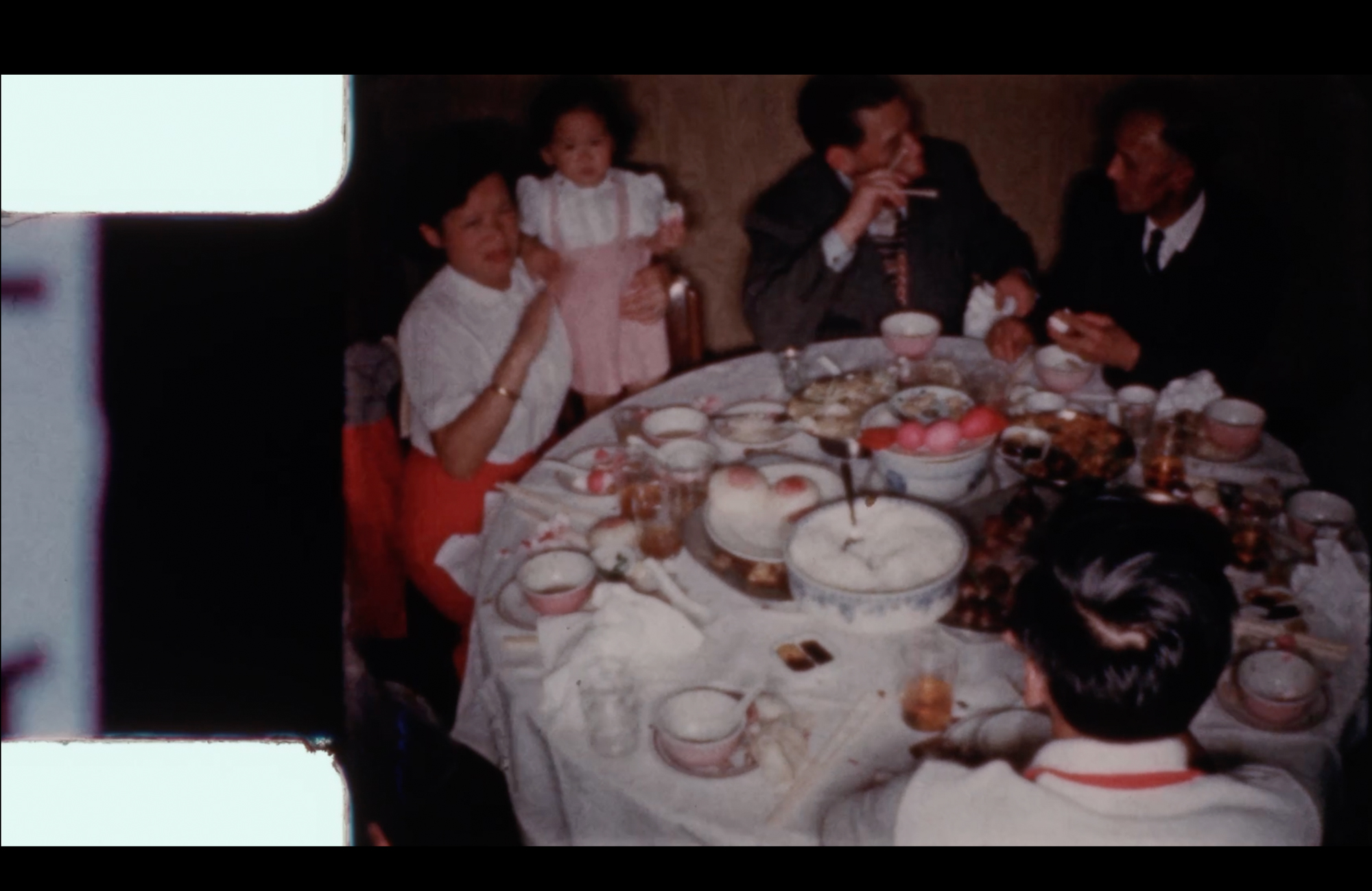 photograph of Asian family eating around circular table in banquet hall