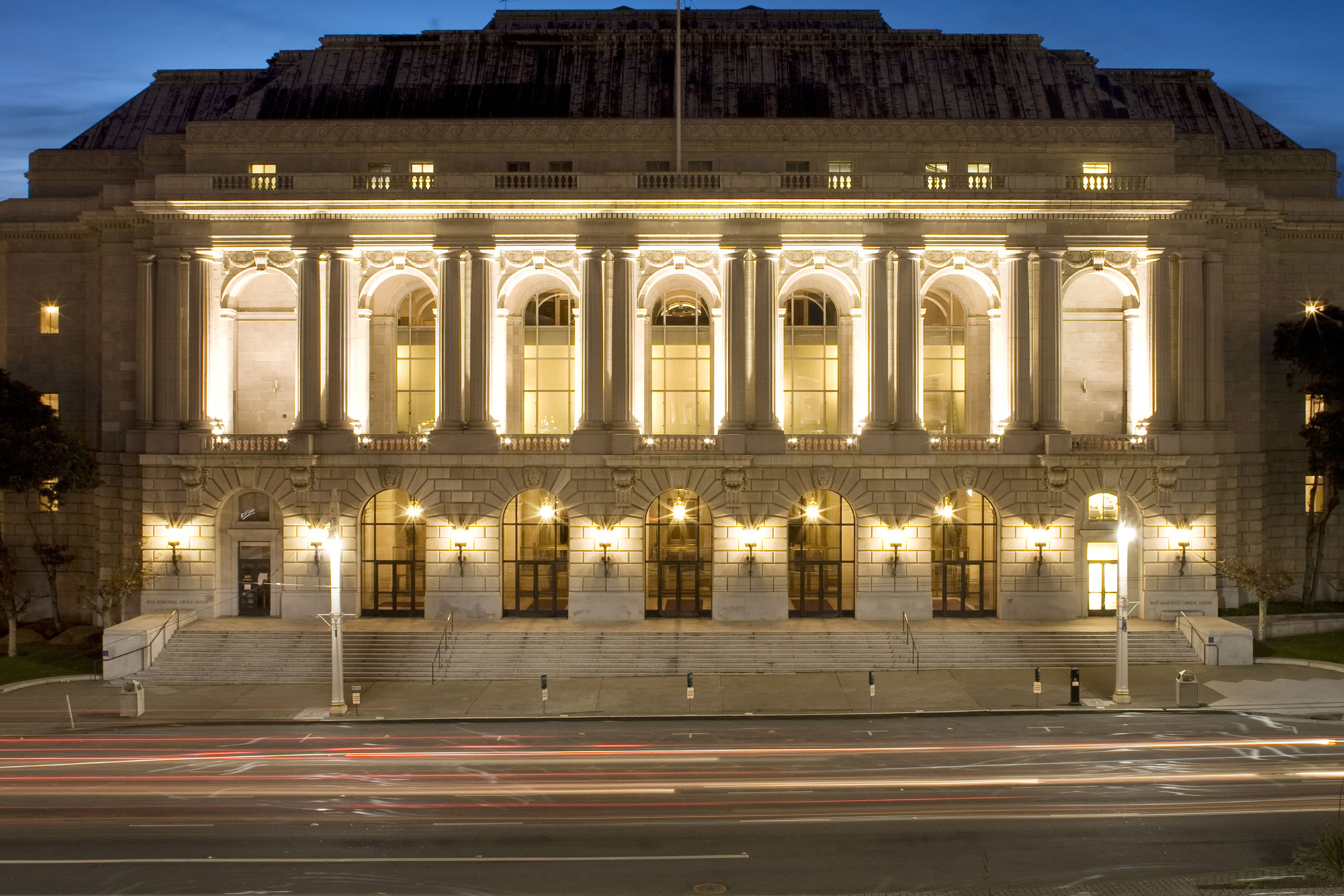 A beaux arts bulding with large columns, lit up at night