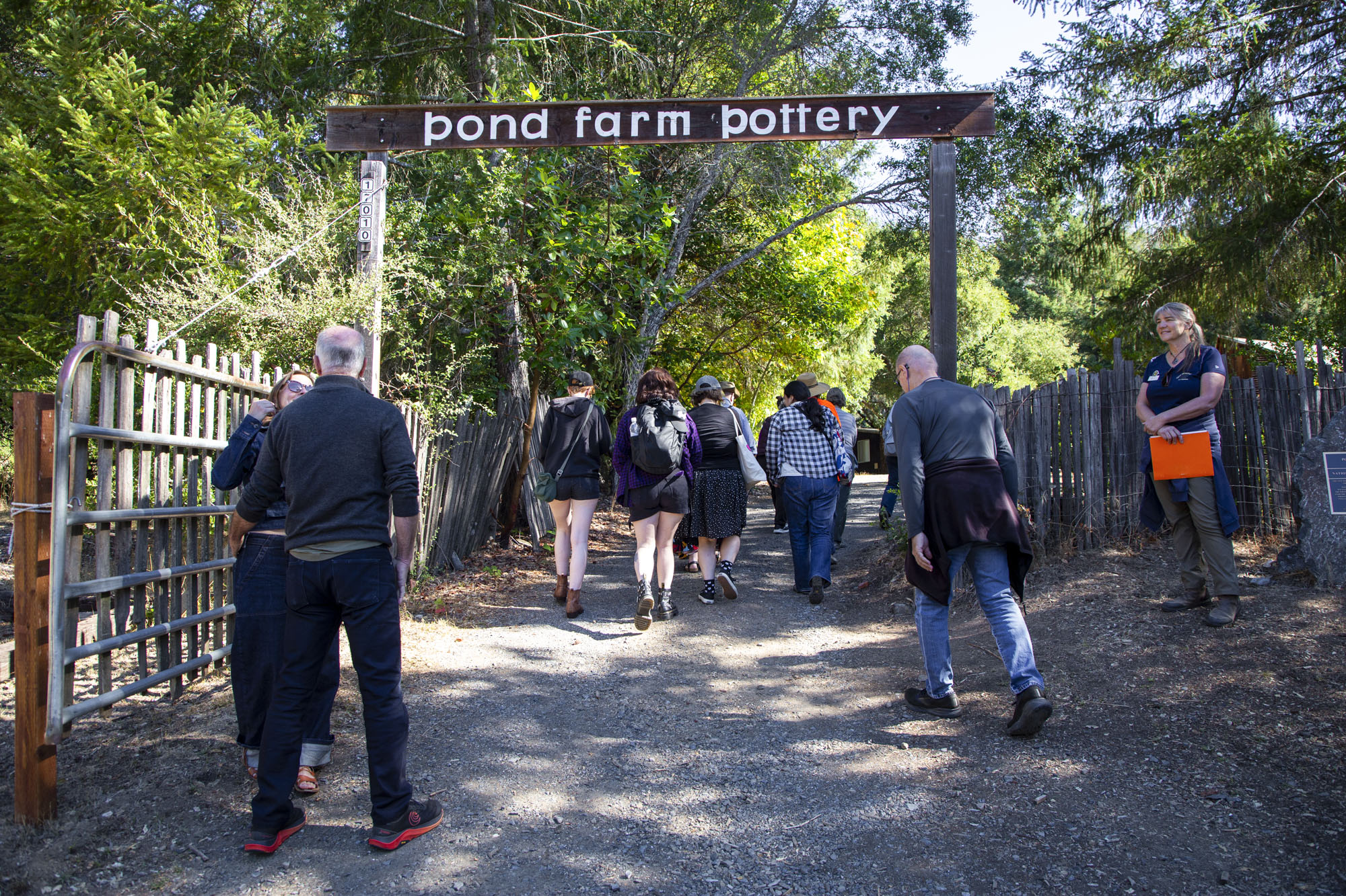 small crowd of hikers pass under sign