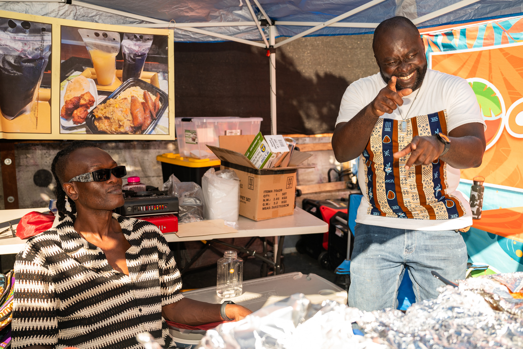 Two smiling food vendors at a food festival.