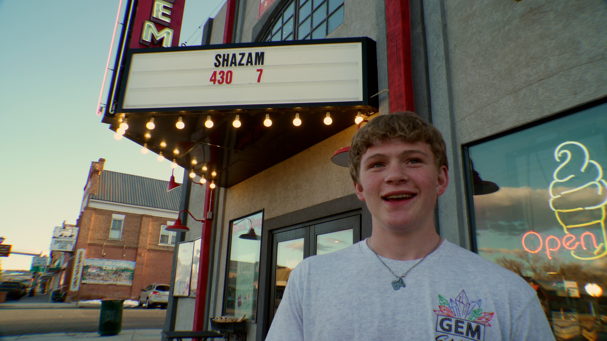 young white person in front of movie theater marquee