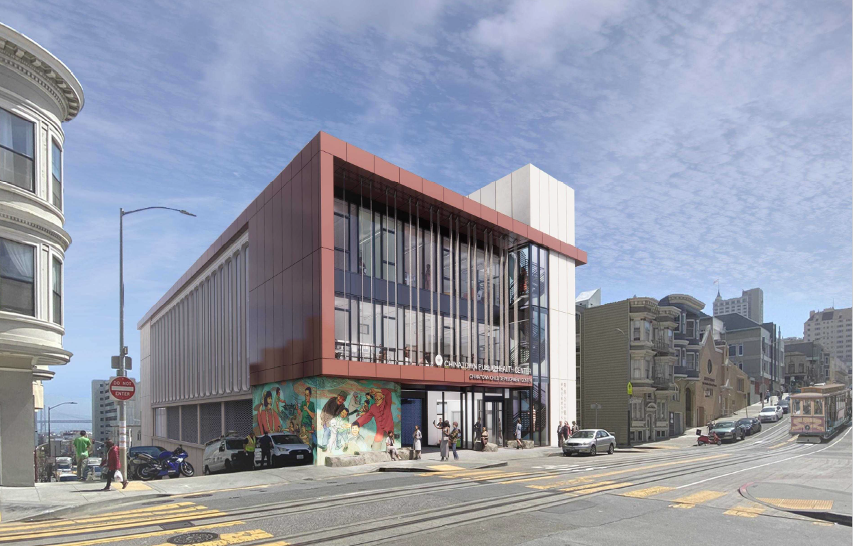 square building on corner with colorful mural at street level
