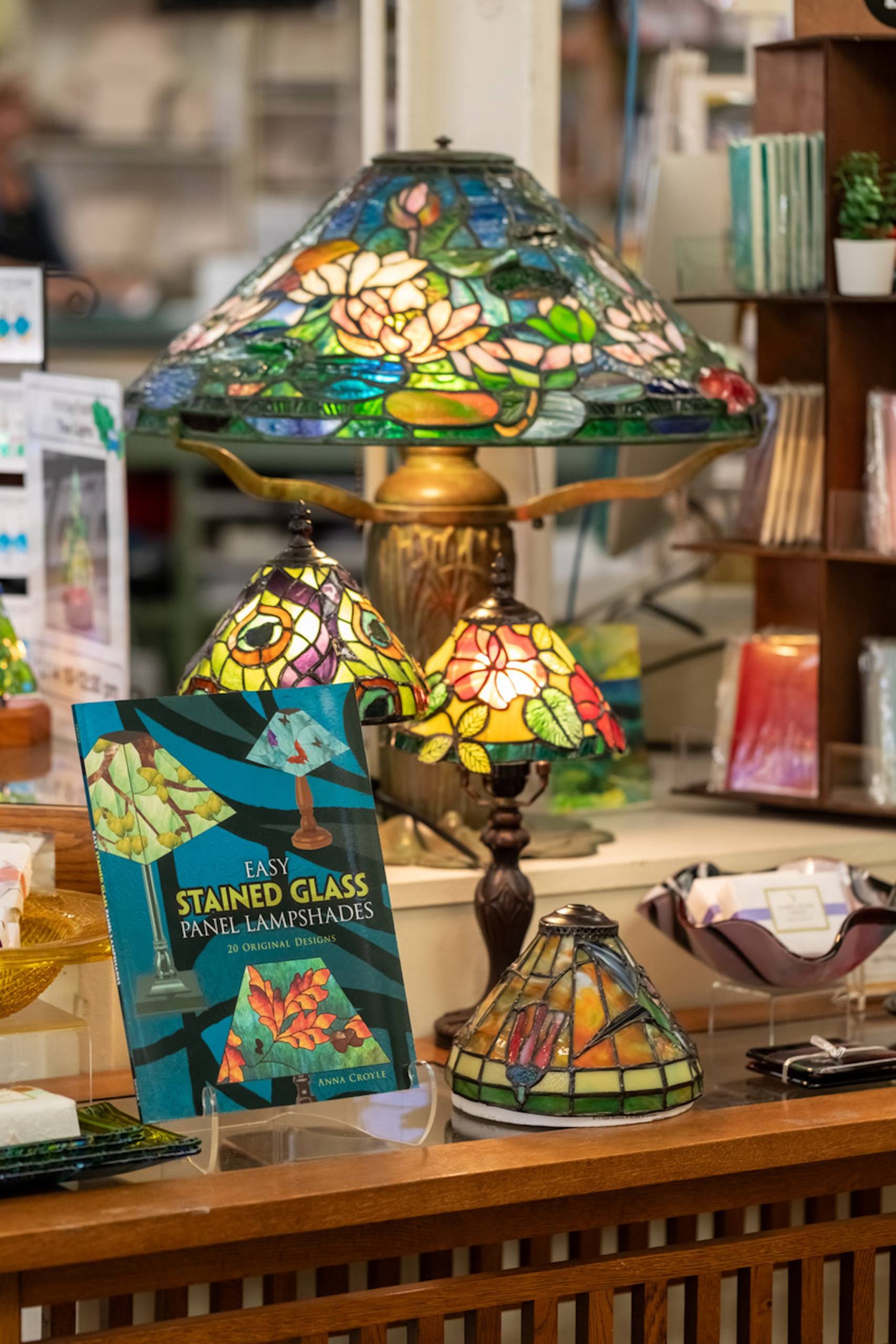 A display of items made of stained glass, including a colorful lamp.