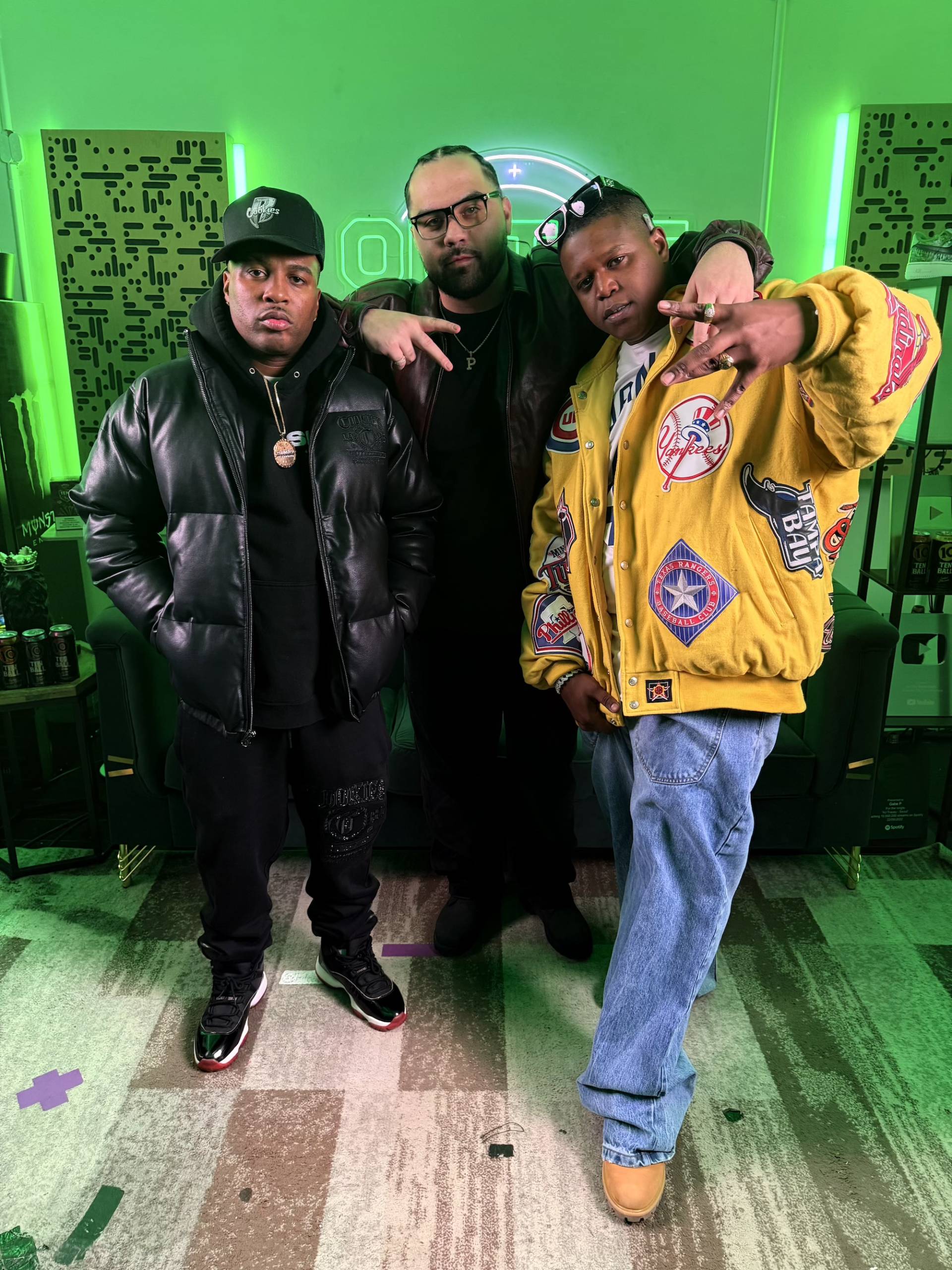 Three men in a recording studio, posing for a photo.