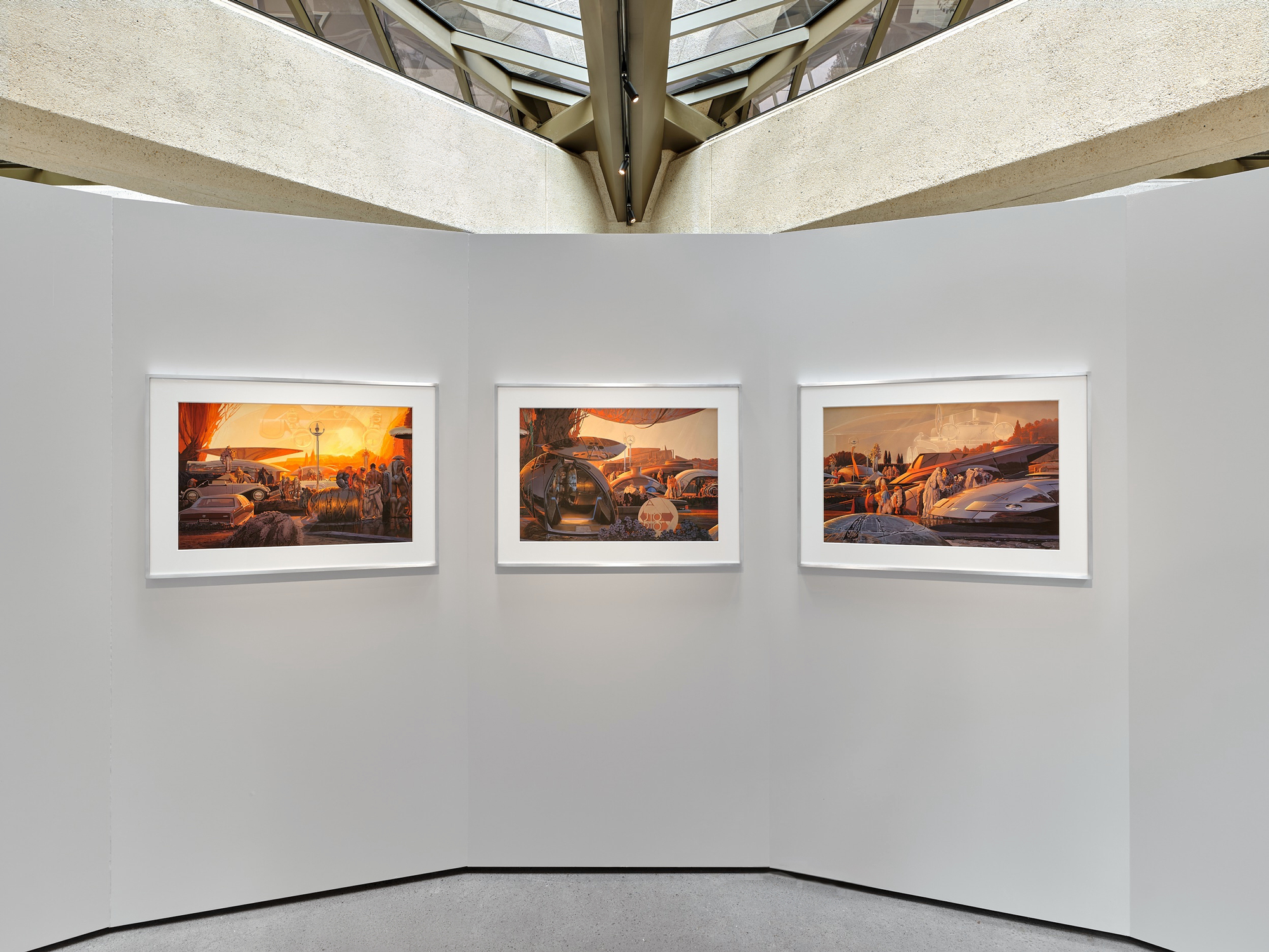 three framed gouache paintings on gray wall under concrete structure
