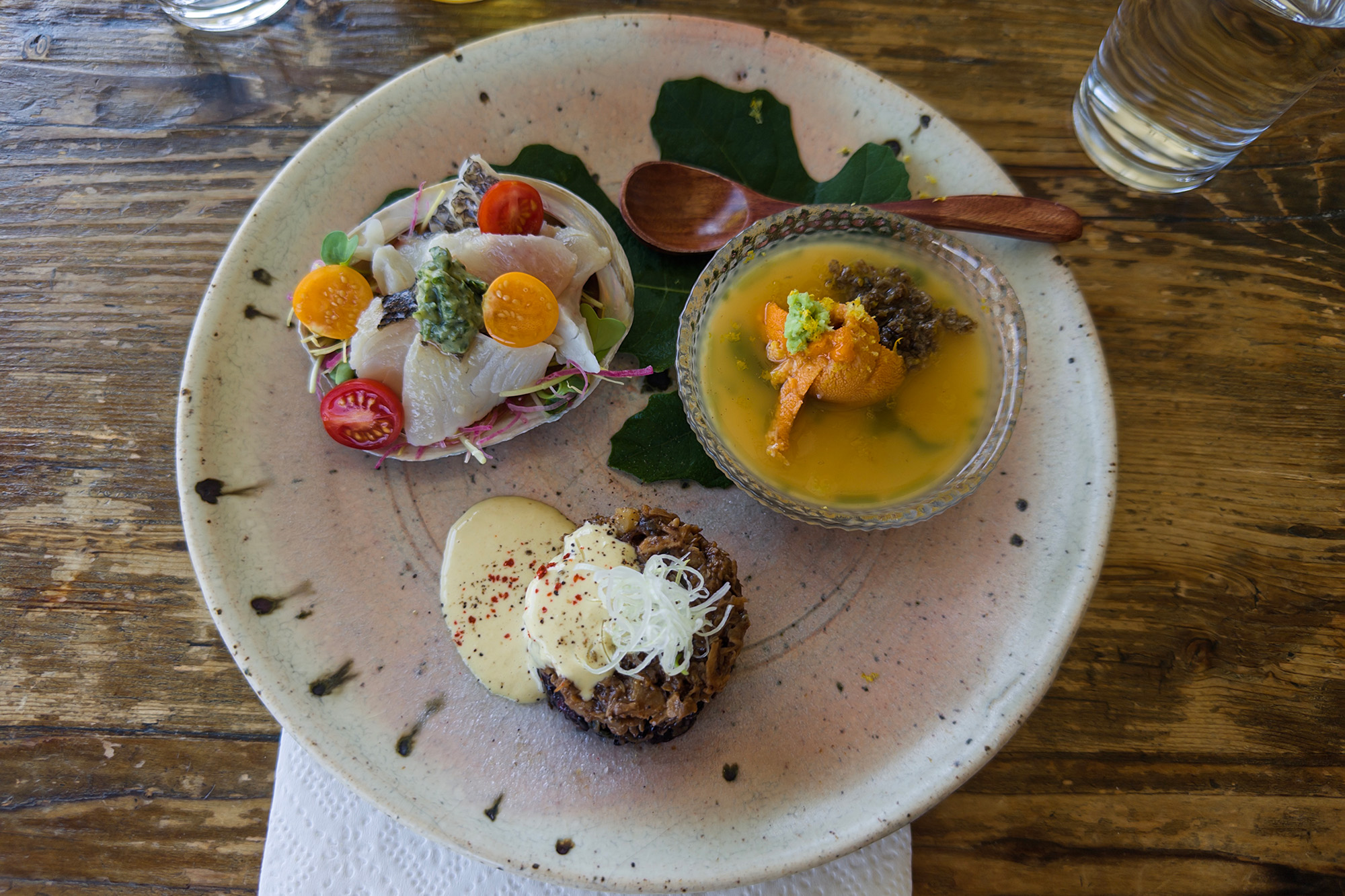 A trio of Japanese appetizers on a plate: sashimi, egg custard and a pate-like head cheese.