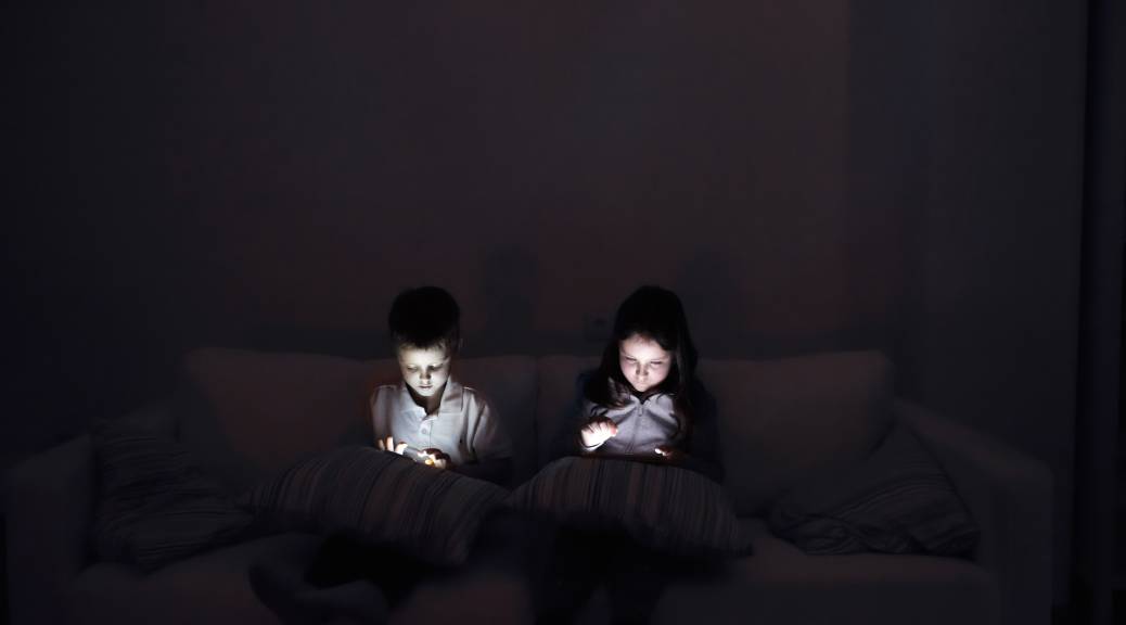 Two children having screen time in the dark