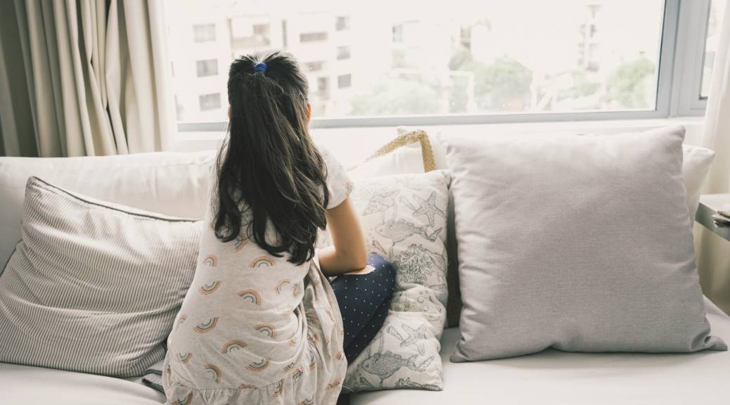 Depressed tween girl looking out window