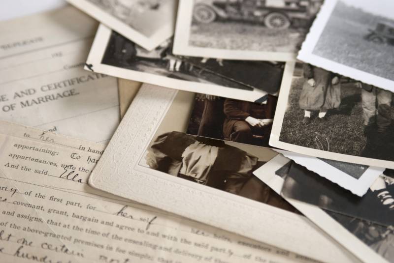 the corners of black and white photos on top of an old document