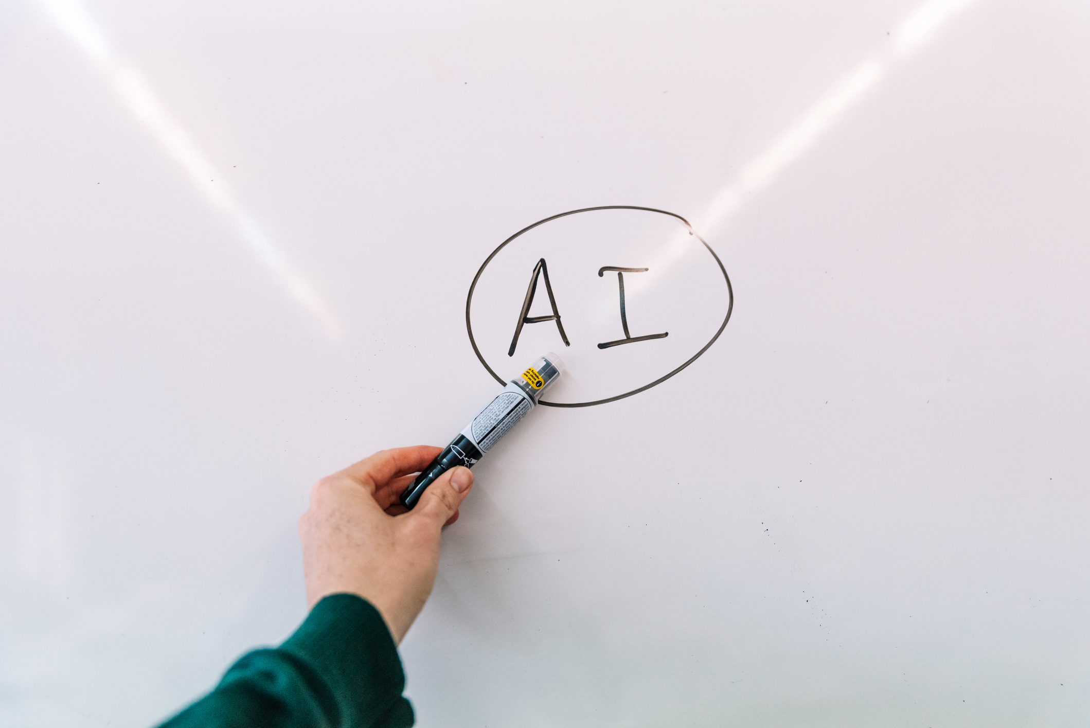 Man's hand showing a blackboard with Artificial Intelligence written on it.