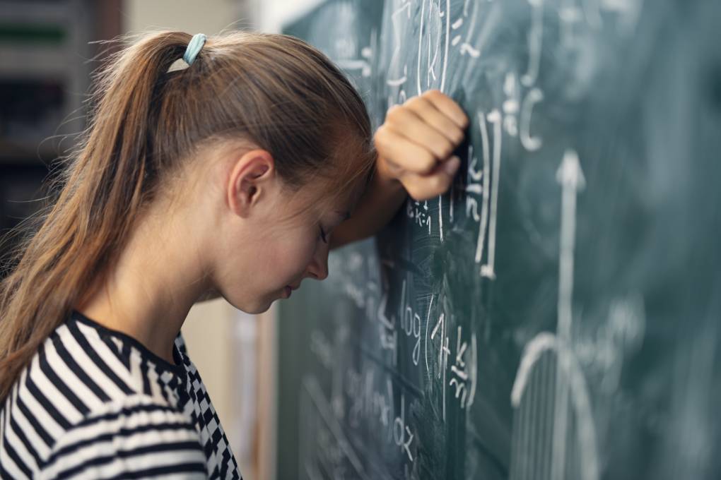 Teenage girl in math class overwhelmed by the math formula.