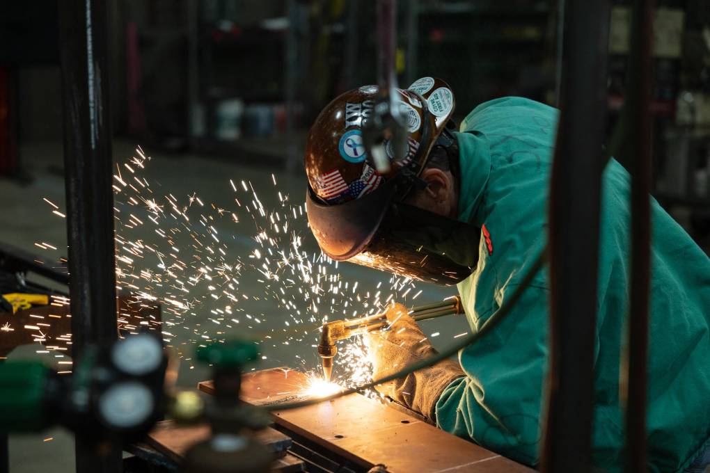 Sparks fly as a person in a welding mask is at work.