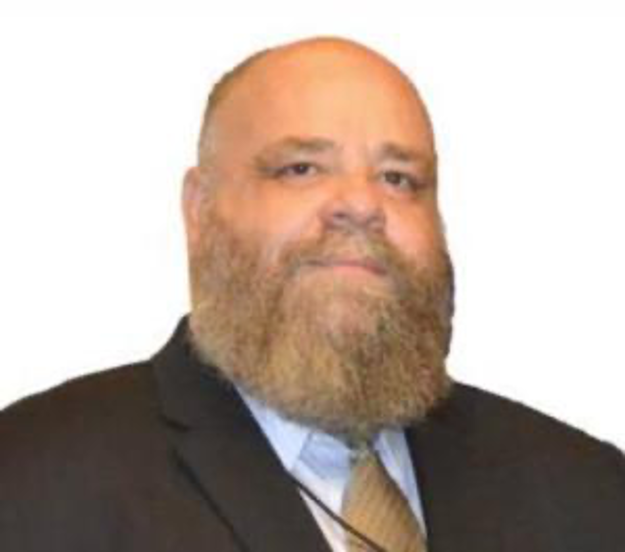 Headshot of a bearded man in a suit.