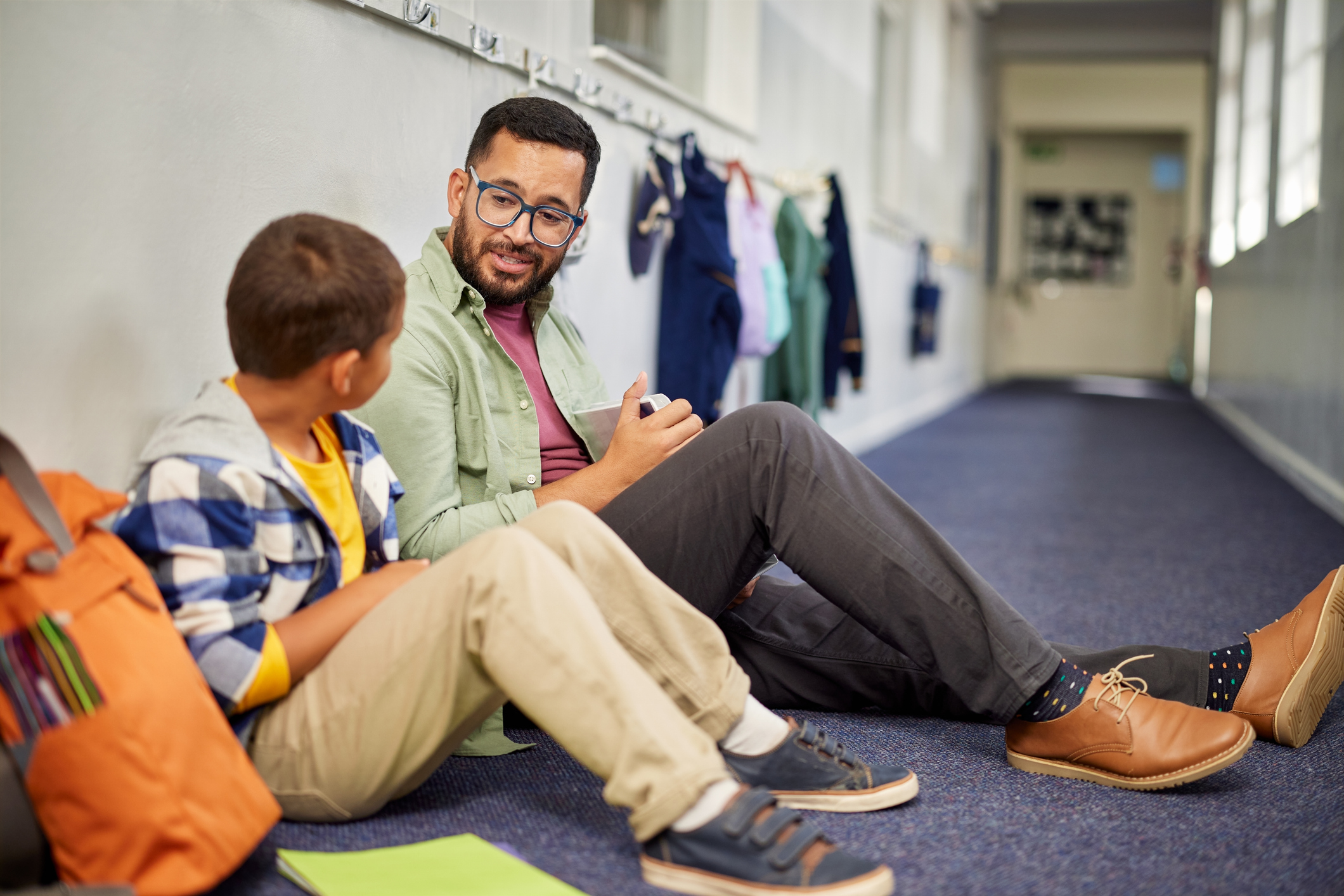 Teacher talking to young sad student
