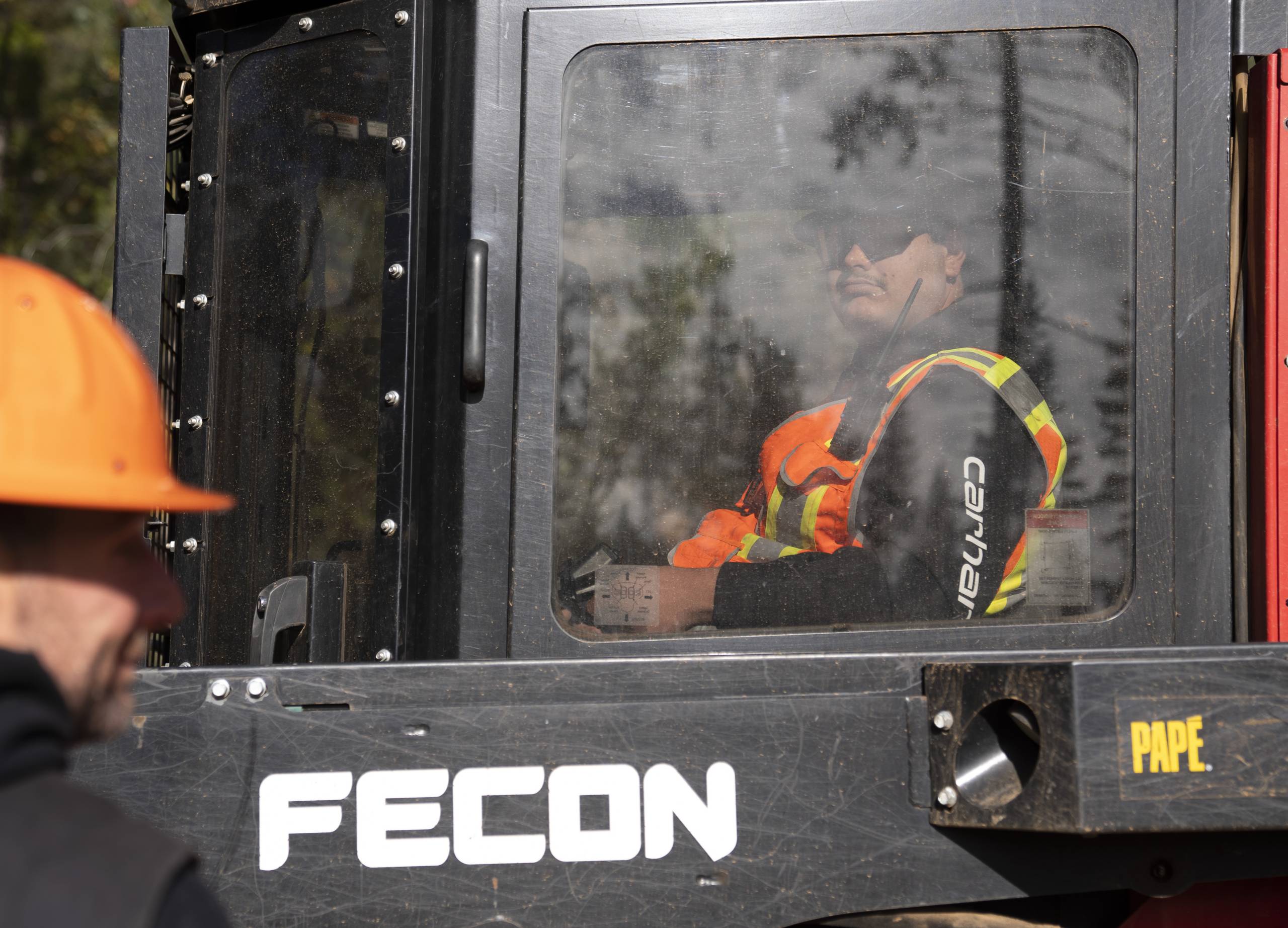 Person operating heavy machinery while being supervised