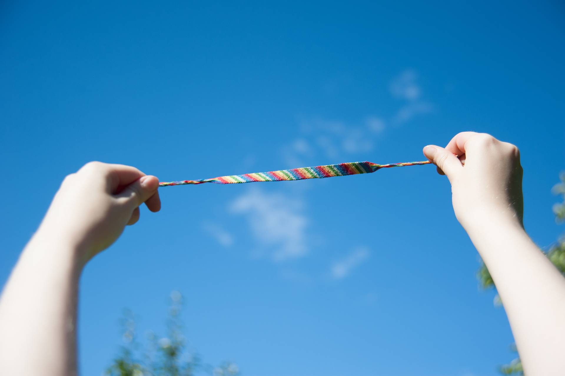 rainbow bracelet from threads on a background of blue sky