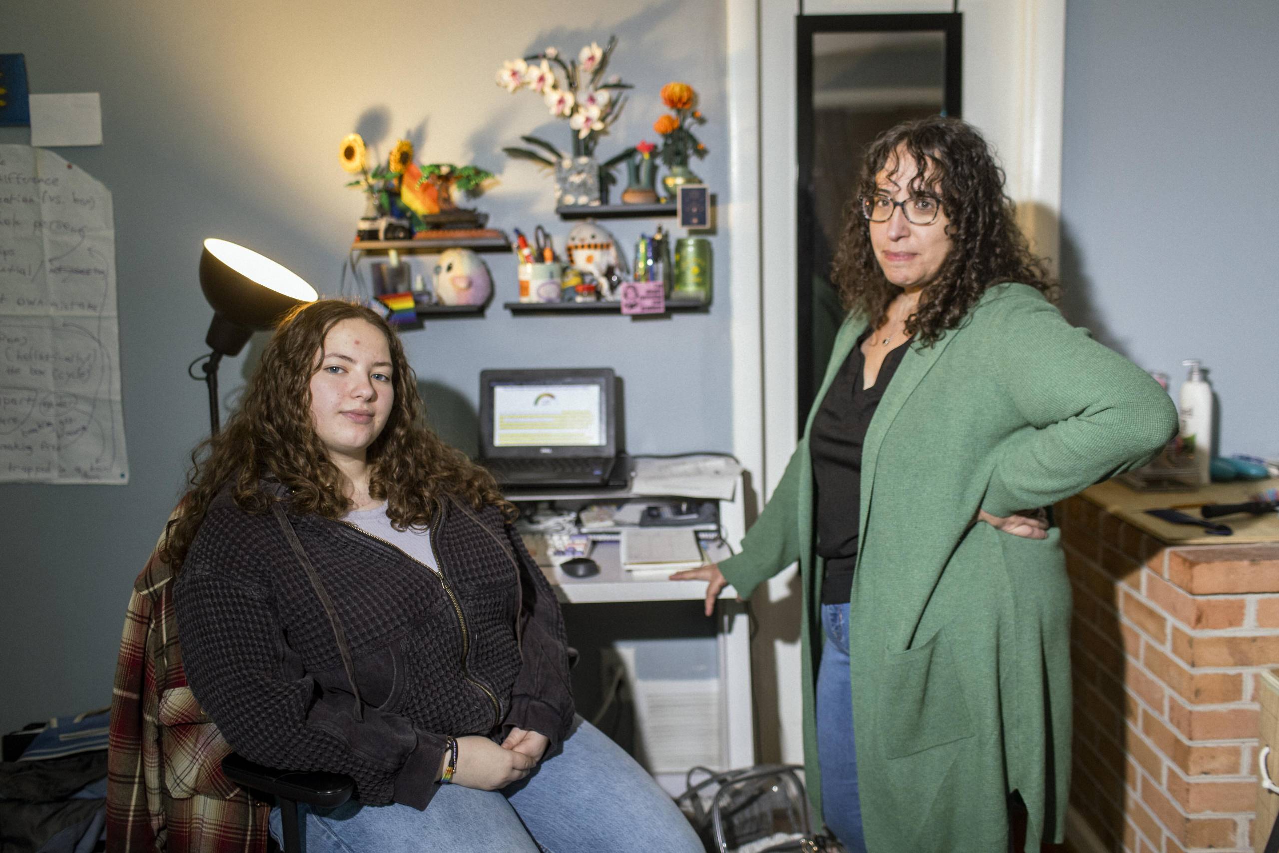 A teen and her mom in front of a desk.