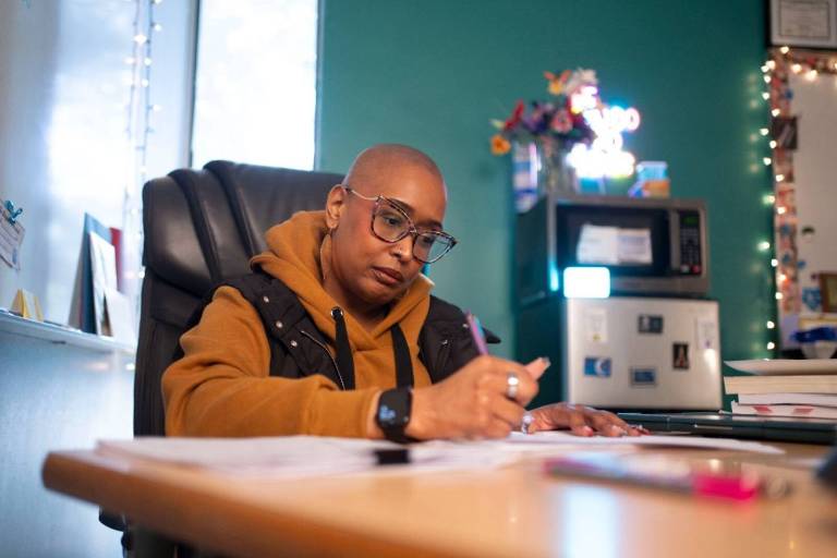 Woman at desk in classroom grading papers
