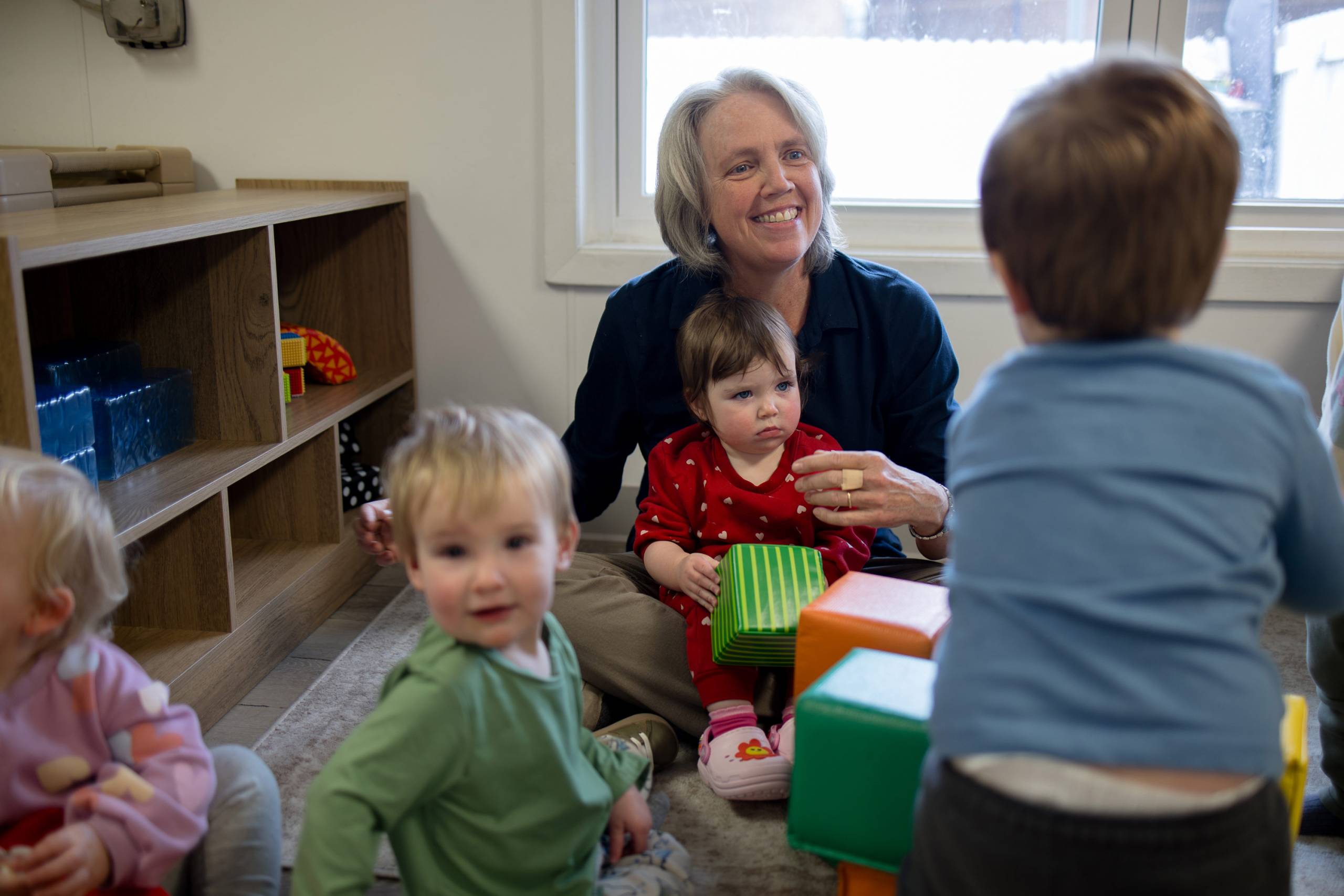 Older woman playing with toddlers