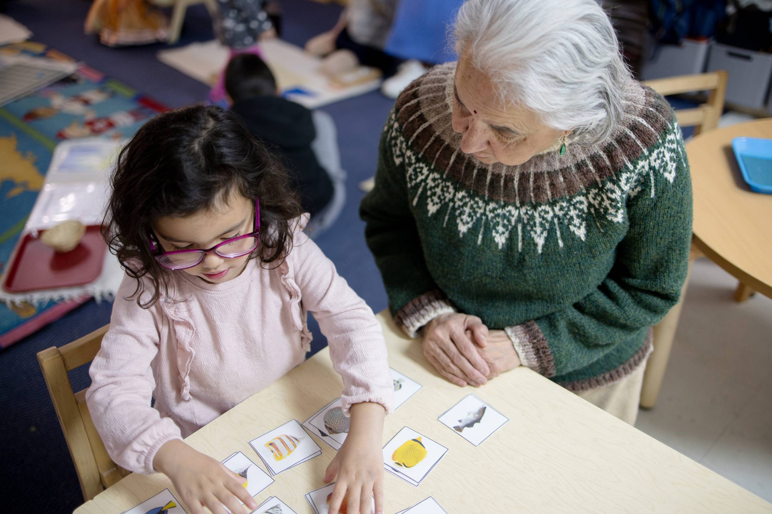 Older woman next to learning child