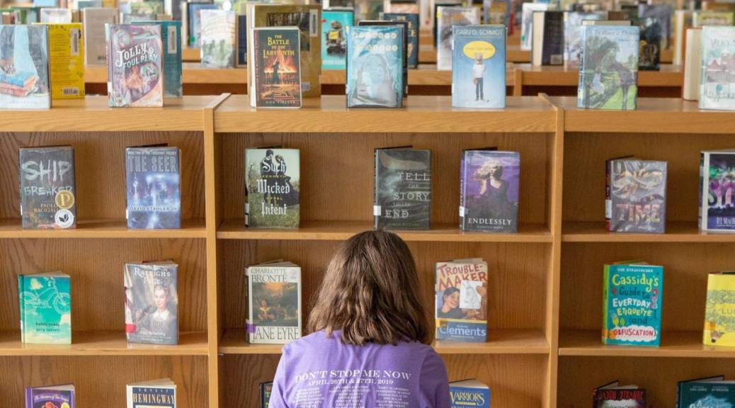 Student in front of rows of books