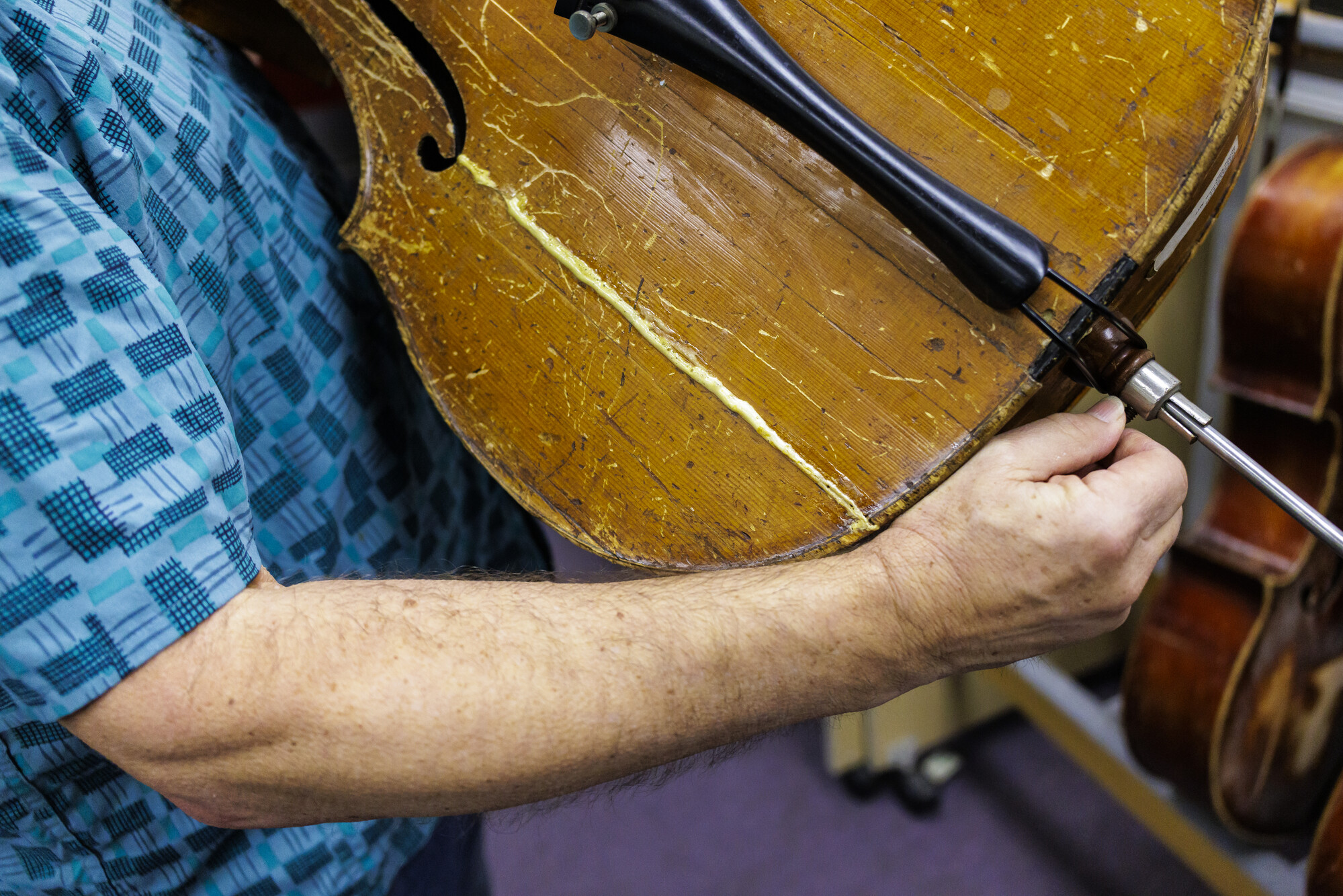 Man holds repaired cello