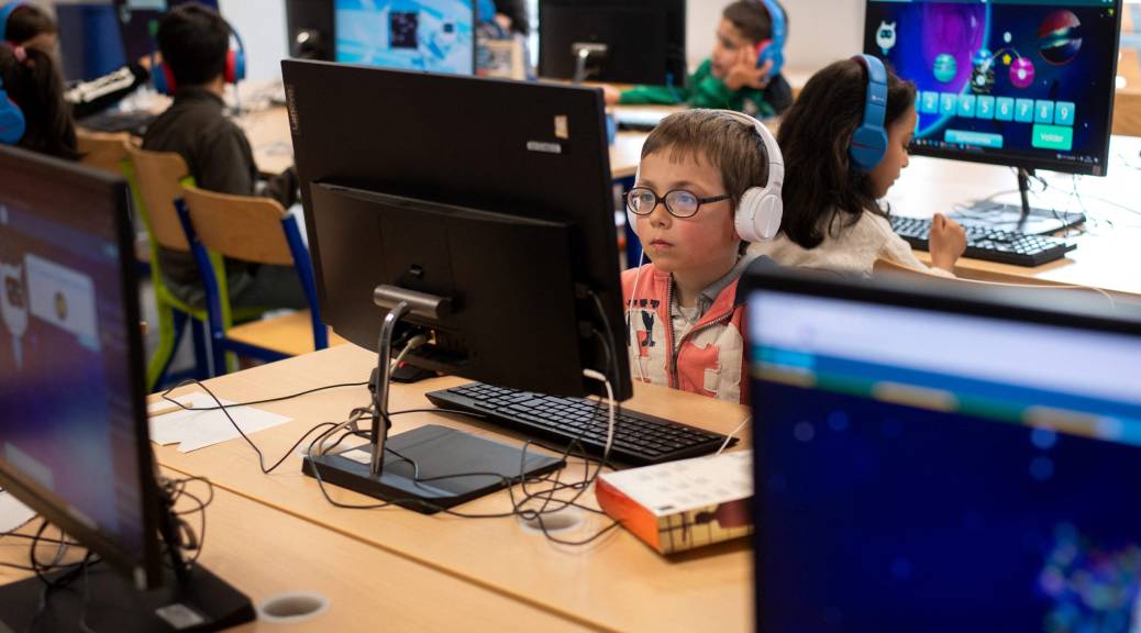 Student sits at desk in front of computer.